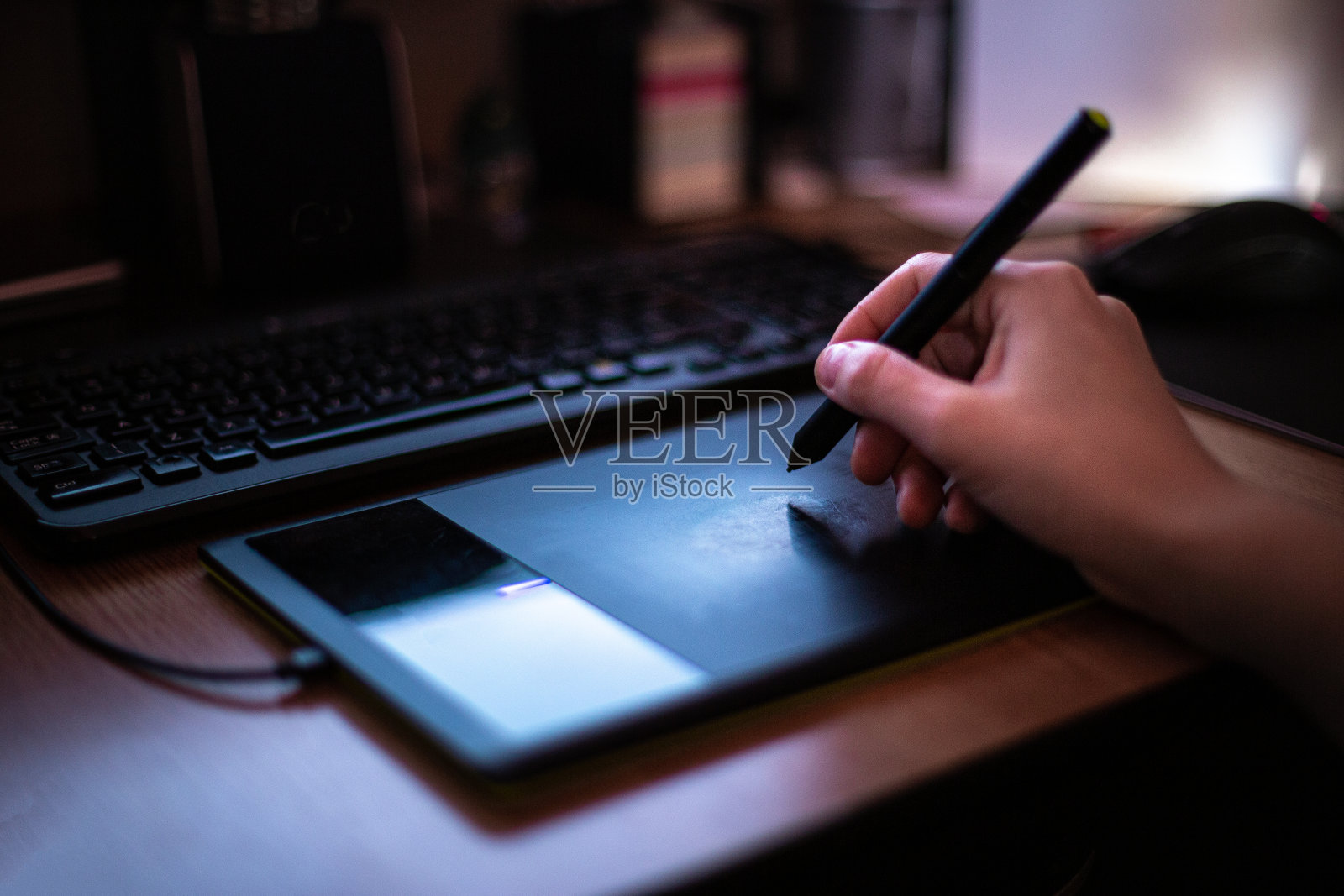 一个人在显示器昏暗的灯光下，用笔和图形板研究新的项目想法照片摄影图片