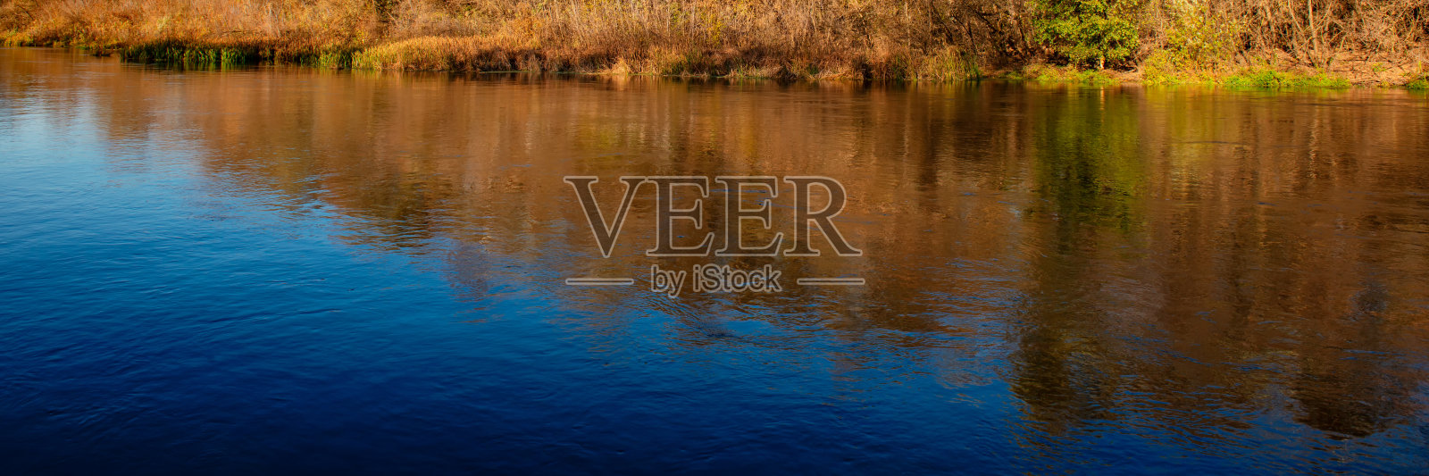 河水表面的倒影。照片摄影图片