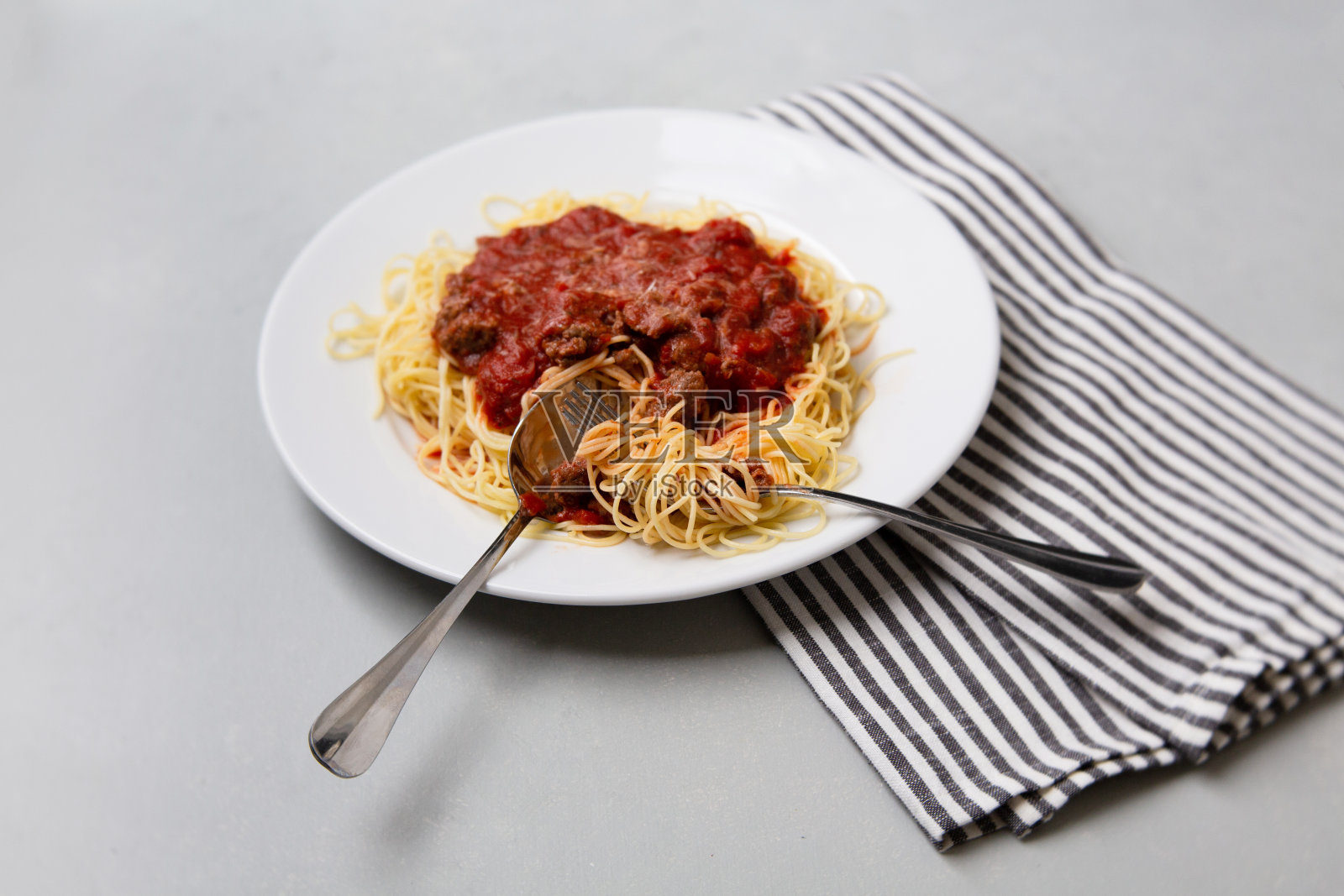 自制肉酱意大利面，白色盘子，灰色背景照片摄影图片