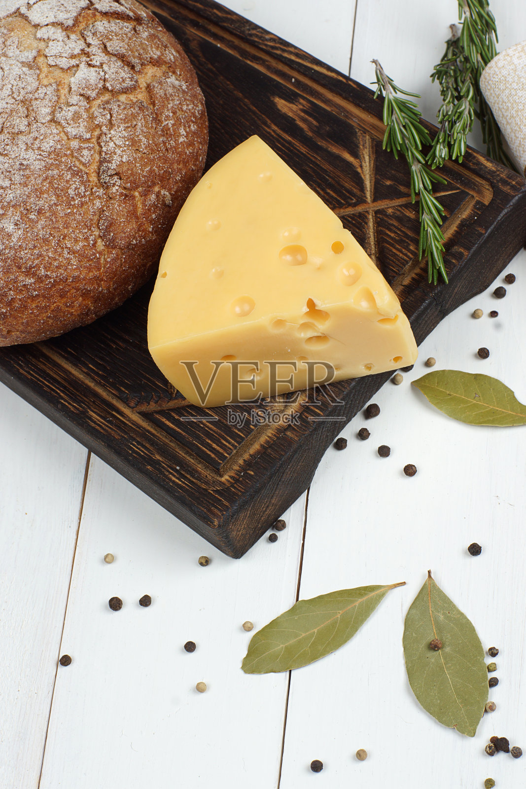 黑麦面包和奶酪躺在一个黑色的木板上，木制的白色桌子，俯视图照片摄影图片