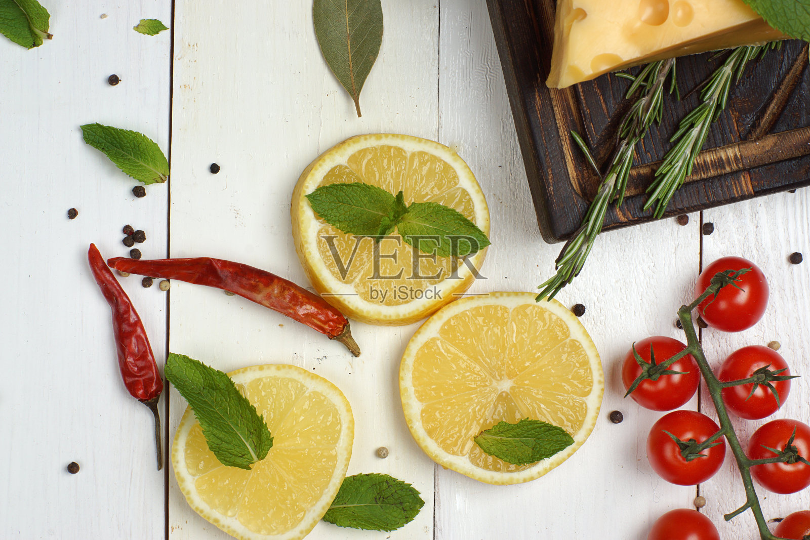 烹饪晚餐前，将柠檬、薄荷和其他产品放在一张白色的木桌上。照片摄影图片