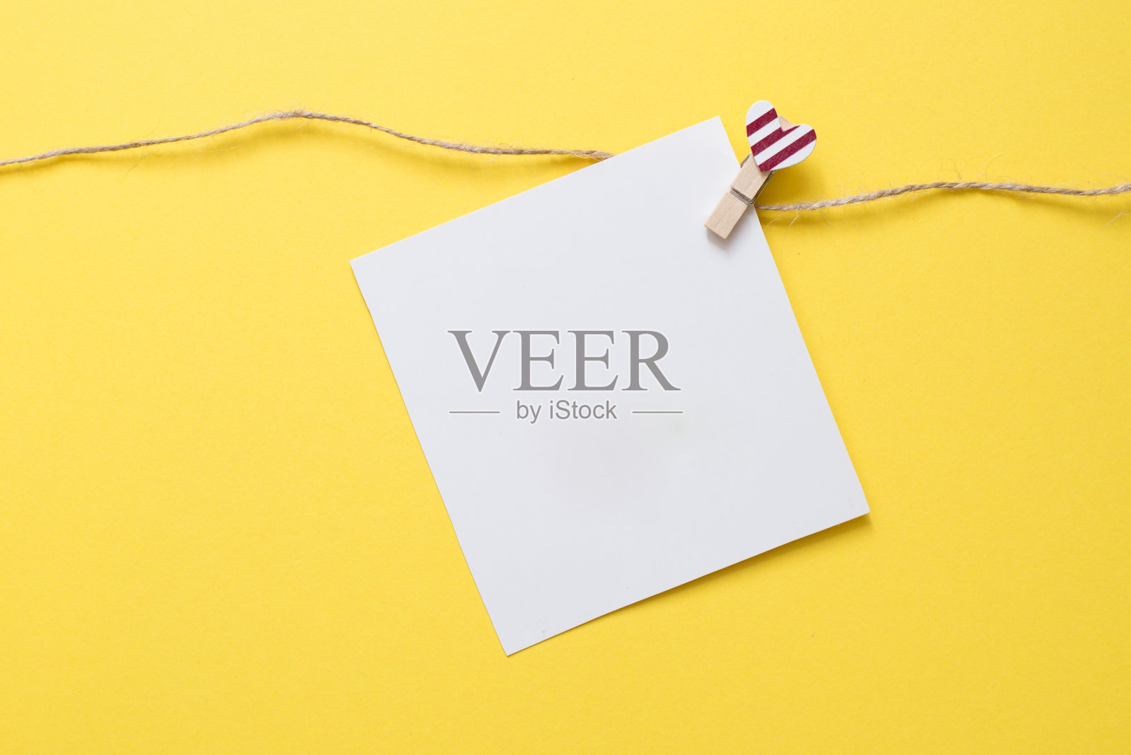 情人节黄色背景上的心形图钉和白色卡片照片摄影图片