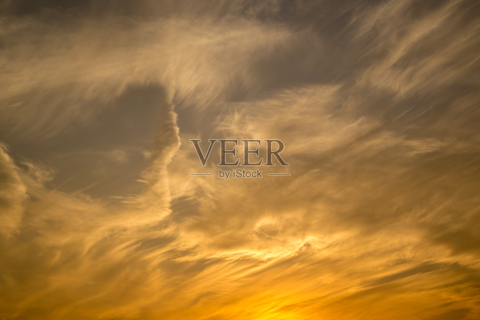 天空中被云切下的落日照亮了。照片摄影图片