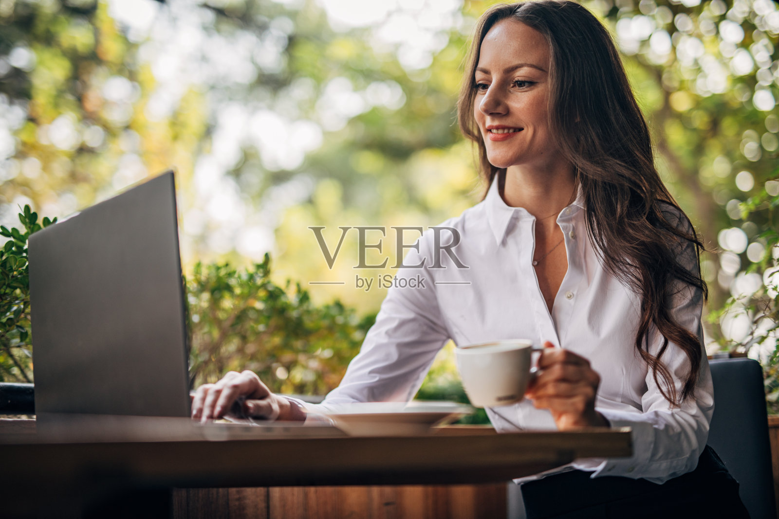 年轻女子在咖啡馆用笔记本电脑工作照片摄影图片