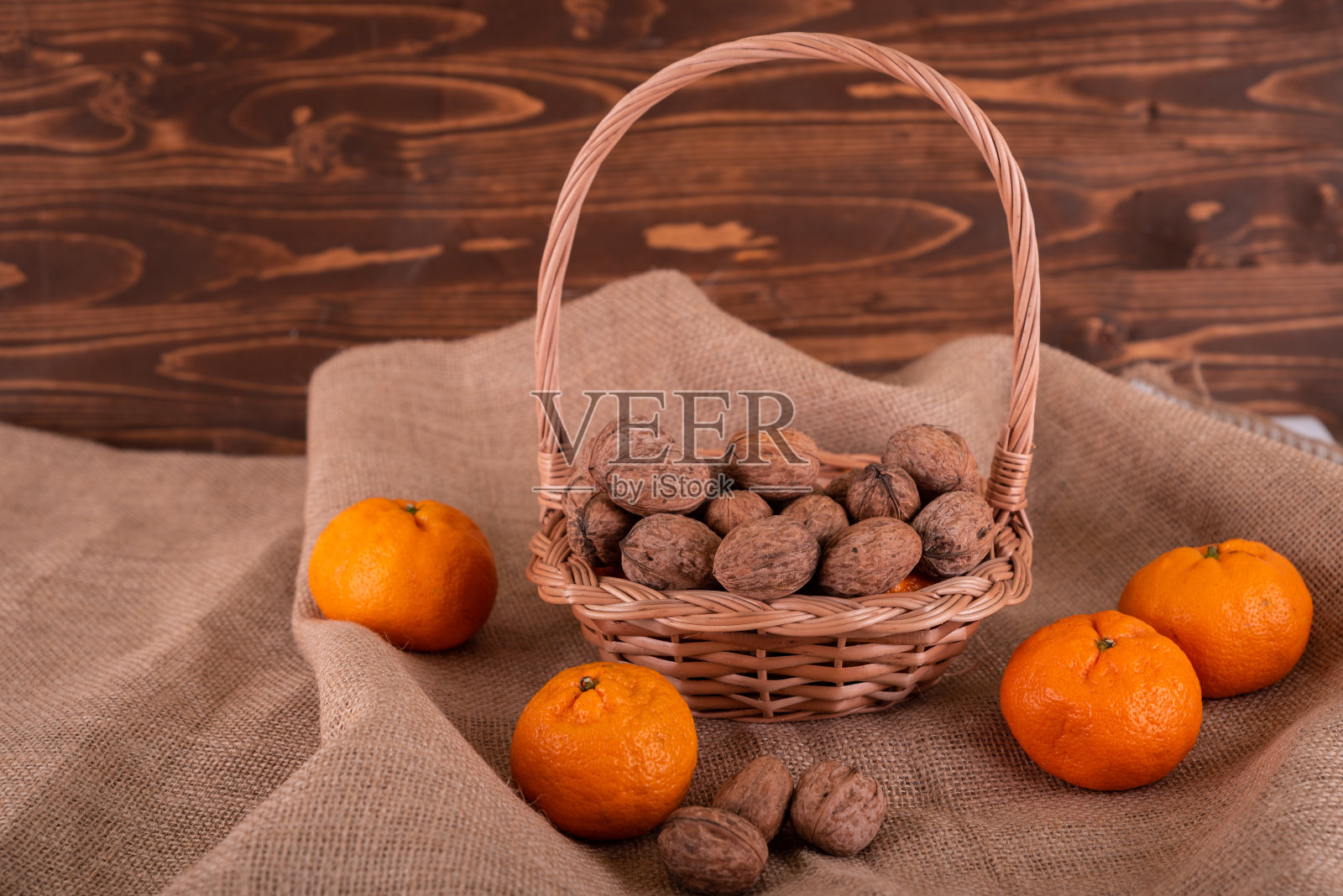 木制的手工篮子，里面有坚果和橘子照片摄影图片
