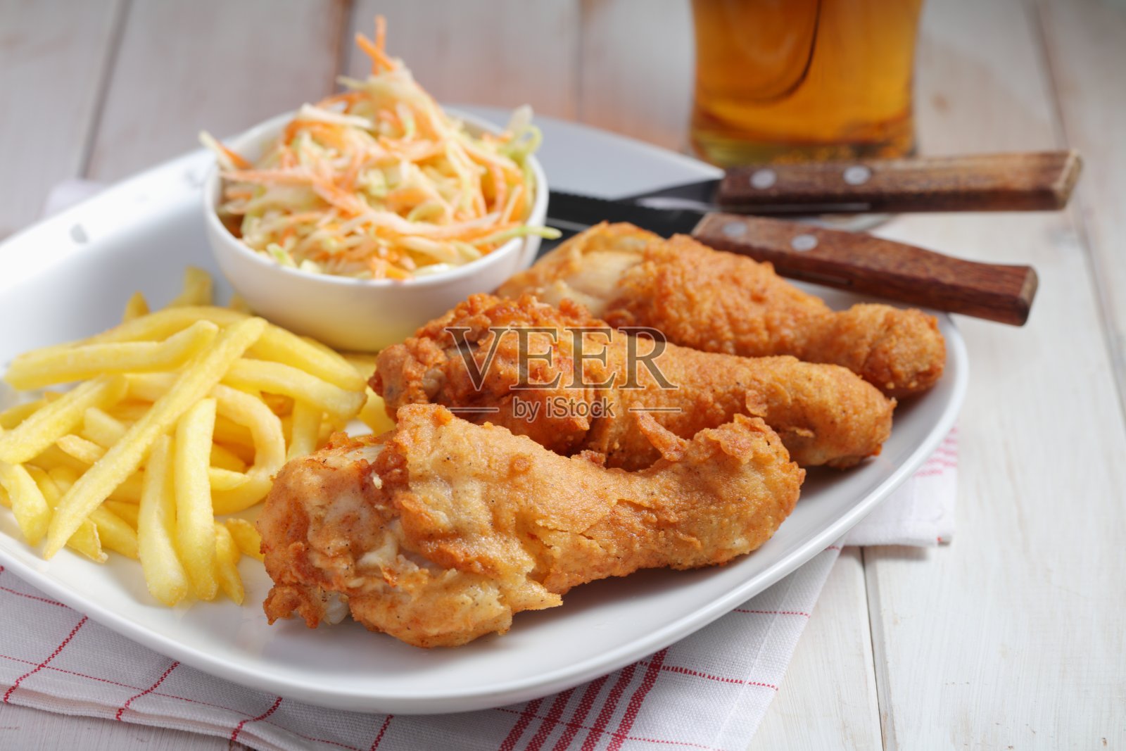 炸鸡腿配薯条，凉拌卷心菜，还有啤酒照片摄影图片