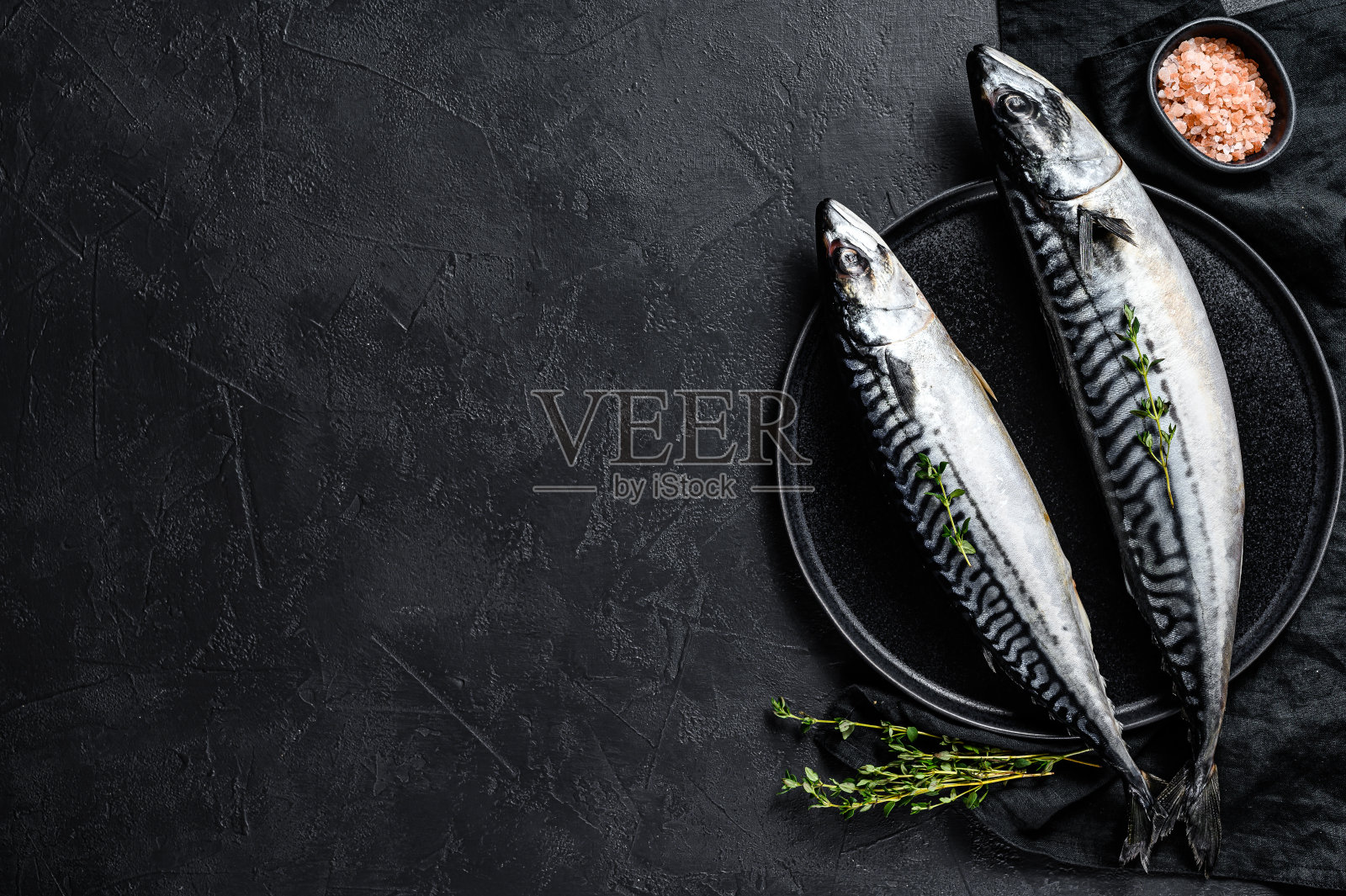 生鲭鱼加百里香和粉盐。新鲜的海鲜。黑色背景。前视图。空间的文本照片摄影图片