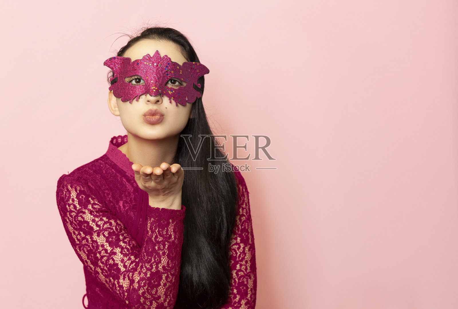 迷人的年轻女士送飞吻，美丽的女人在化妆面具肖像。情人节，狂欢节，节日舞会，生日庆祝概念。面部情绪照片摄影图片