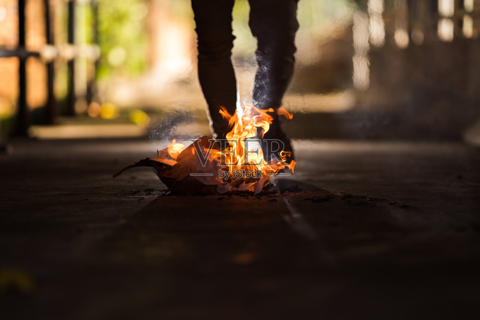 一个男人站在篝火后面。照片摄影图片