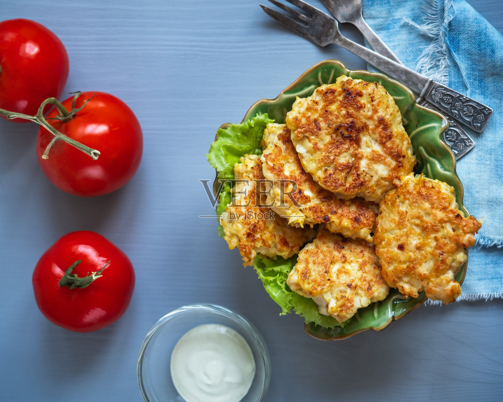 简单的饮食早餐是鸡肉片和生菜在一个绿色的陶瓷沙拉碗，在玻璃炖锅酱汁，红色的西红柿照片摄影图片