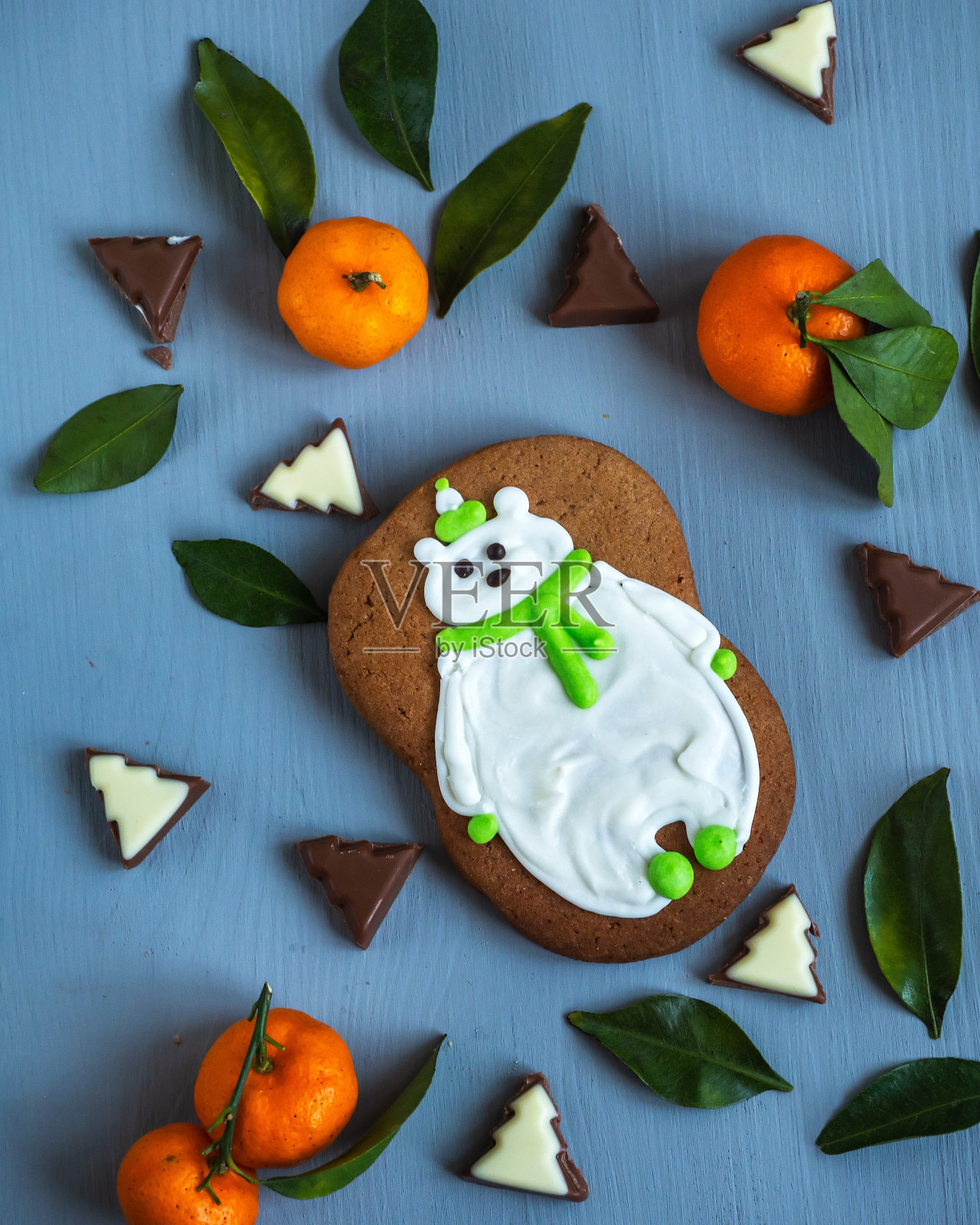 圣诞贺卡上有北极熊形状的姜饼、橘子和巧克力块，照片摄影图片