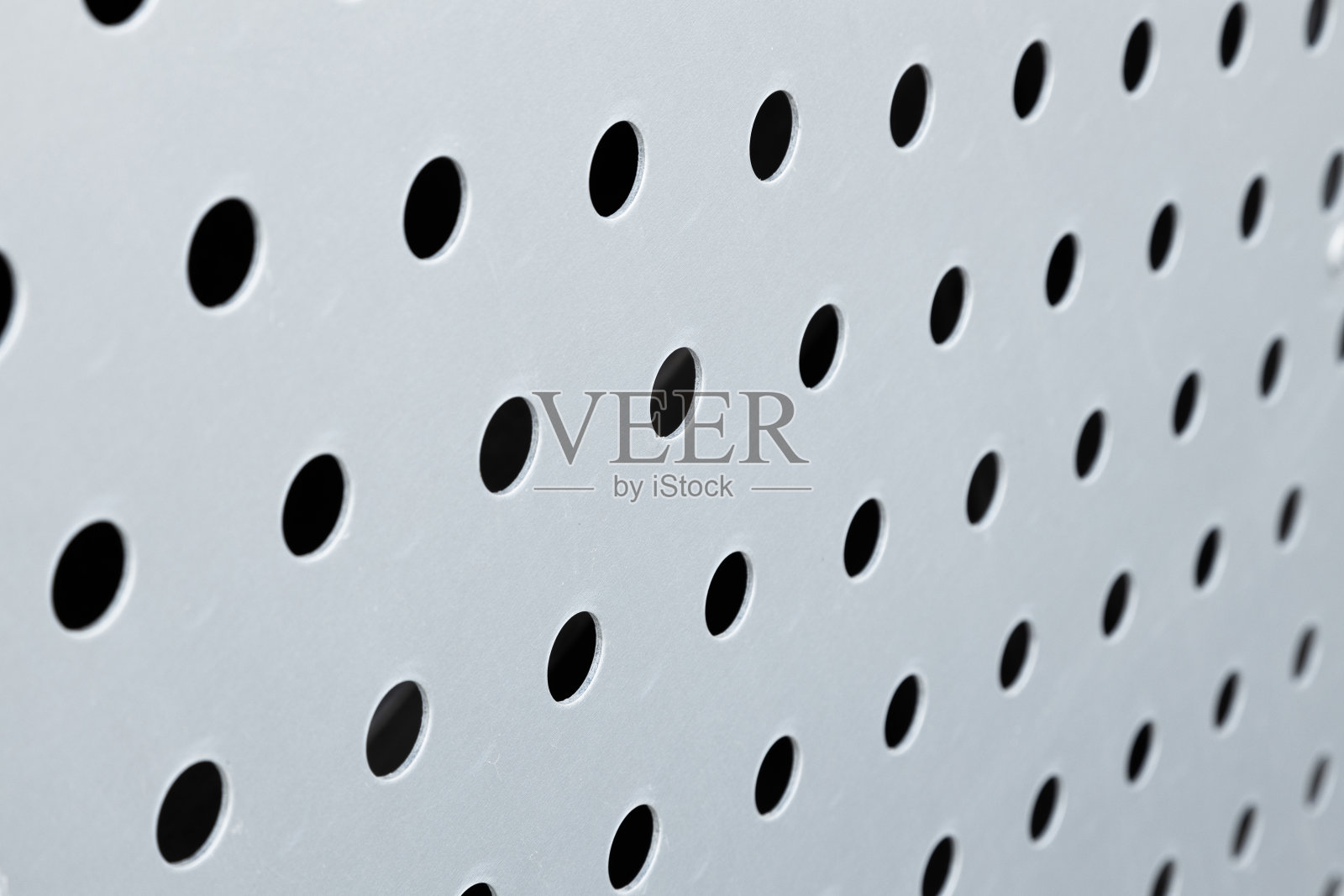 快速黑色大点图案的白色背景，圆孔纹理穿孔金属面板表面。照片摄影图片