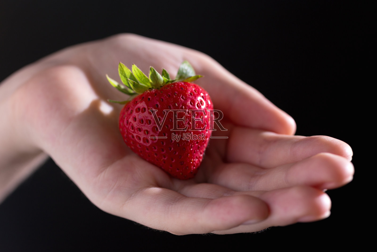 近距离的大红草莓在黑，宏。素食生活，健康饮食照片摄影图片
