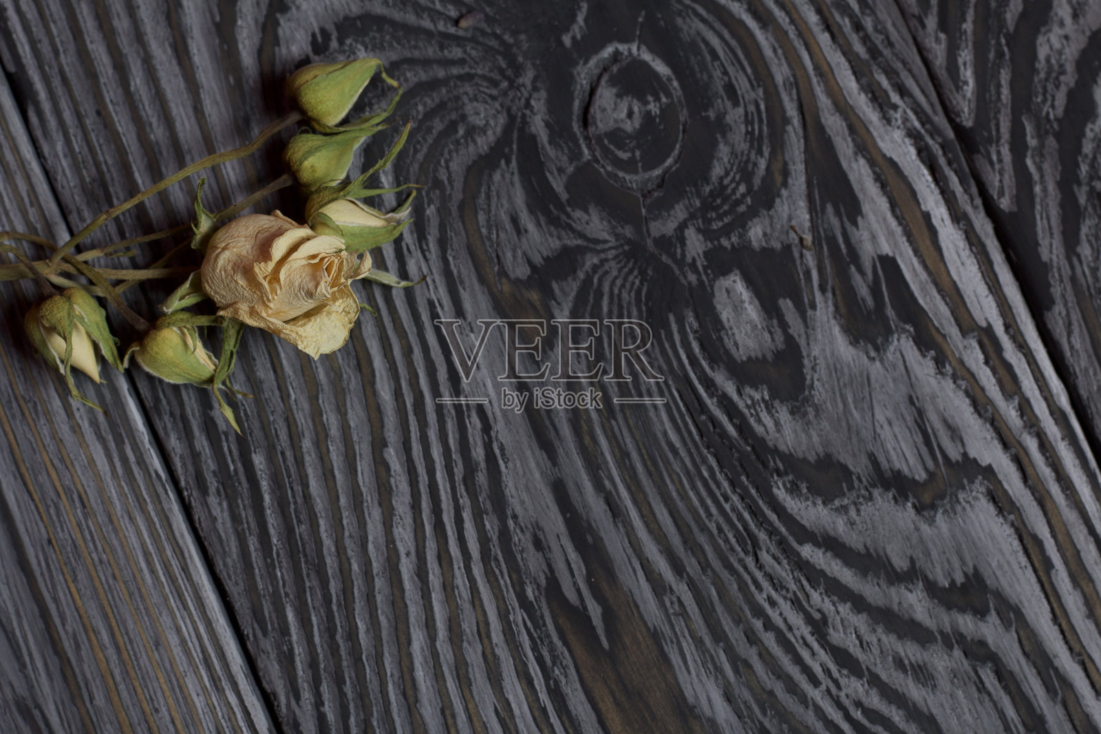 干玫瑰花束，黑色纹理的旧木板背景照片摄影图片