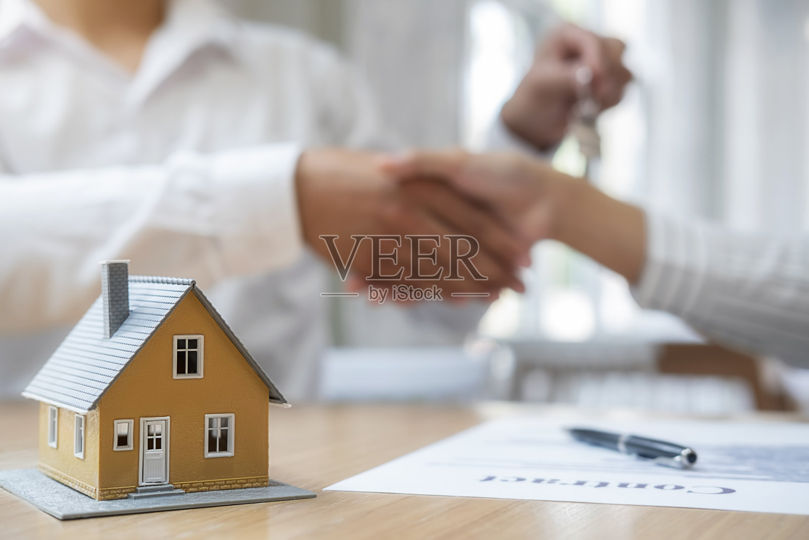 房屋模型：中介和客户讨论购买、保险或贷款房地产合同照片摄影图片