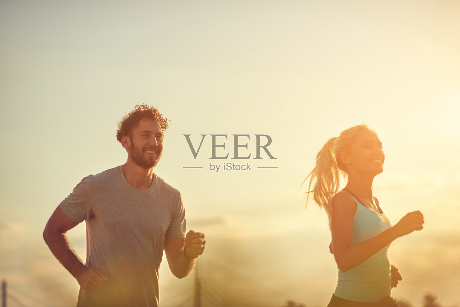 现代女人和男人在河边的城市环境中慢跑/锻炼。照片摄影图片