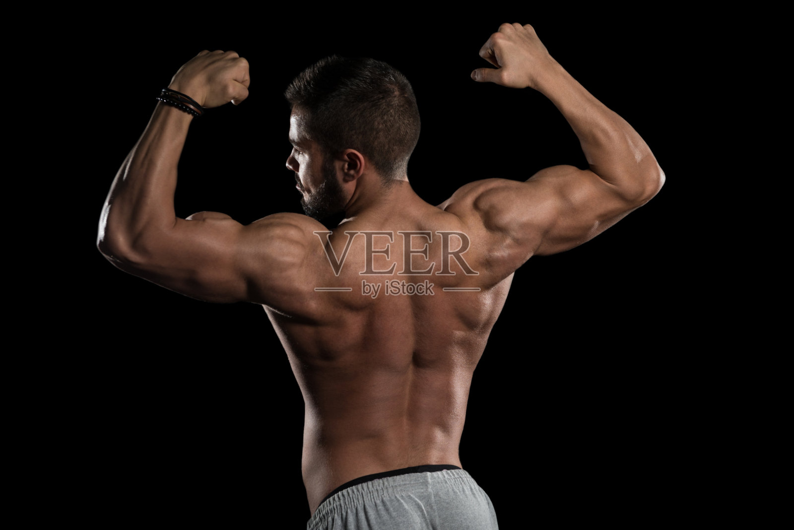 在黑色背景上展示肌肉的健壮运动员照片摄影图片