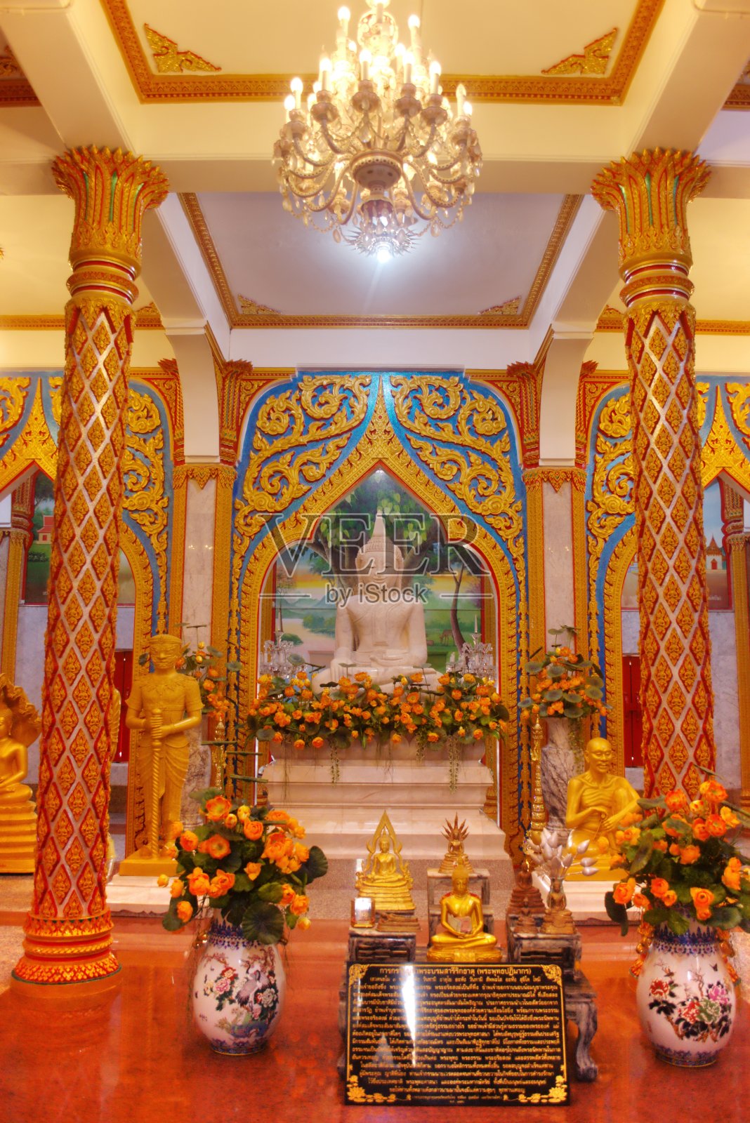 大理石佛像坐佛在一个富丽堂皇的大厅在查龙寺，位于普吉岛，泰国。照片摄影图片