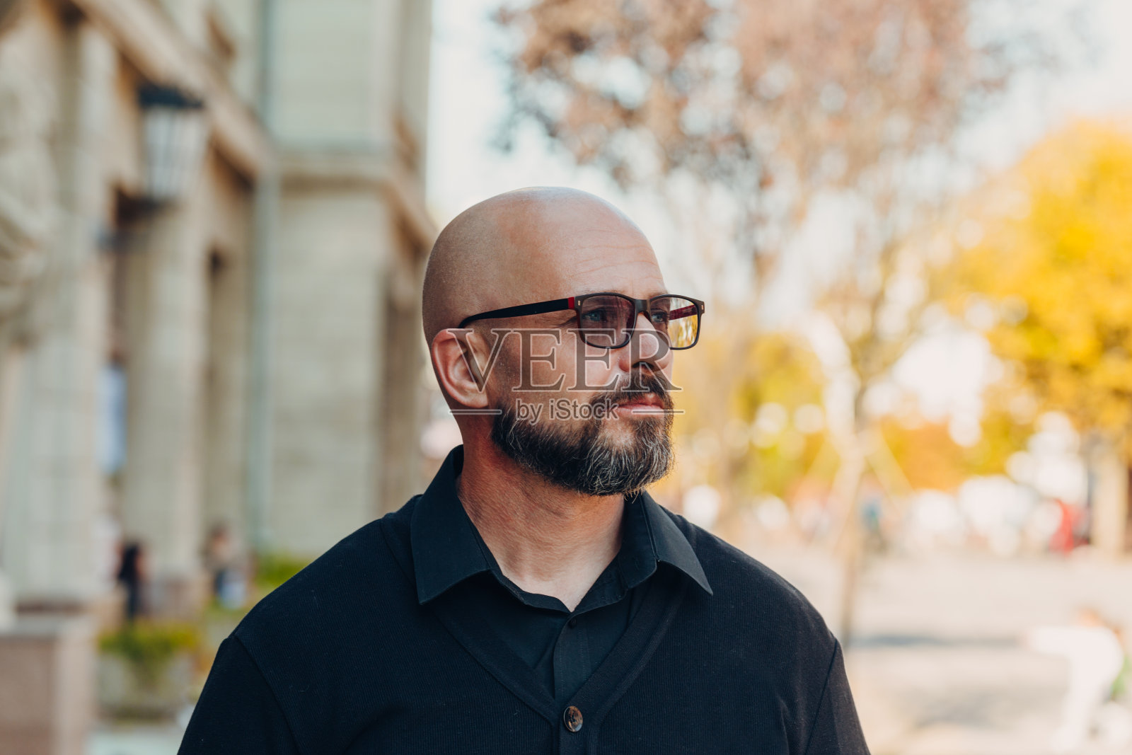 户外肖像的一个50岁快乐的男人穿着黑色衬衫和开襟羊毛衫和眼镜照片摄影图片