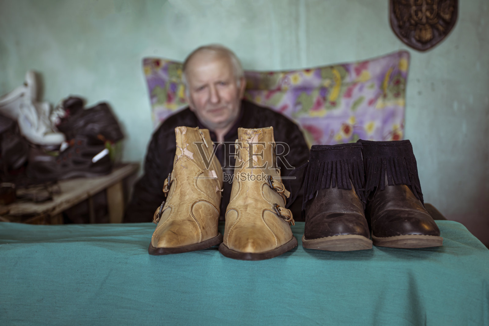 一个上了年纪的鞋匠在他的店里照片摄影图片