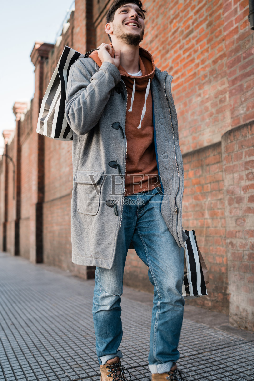 年轻男人拿着购物袋在街上行走照片摄影图片