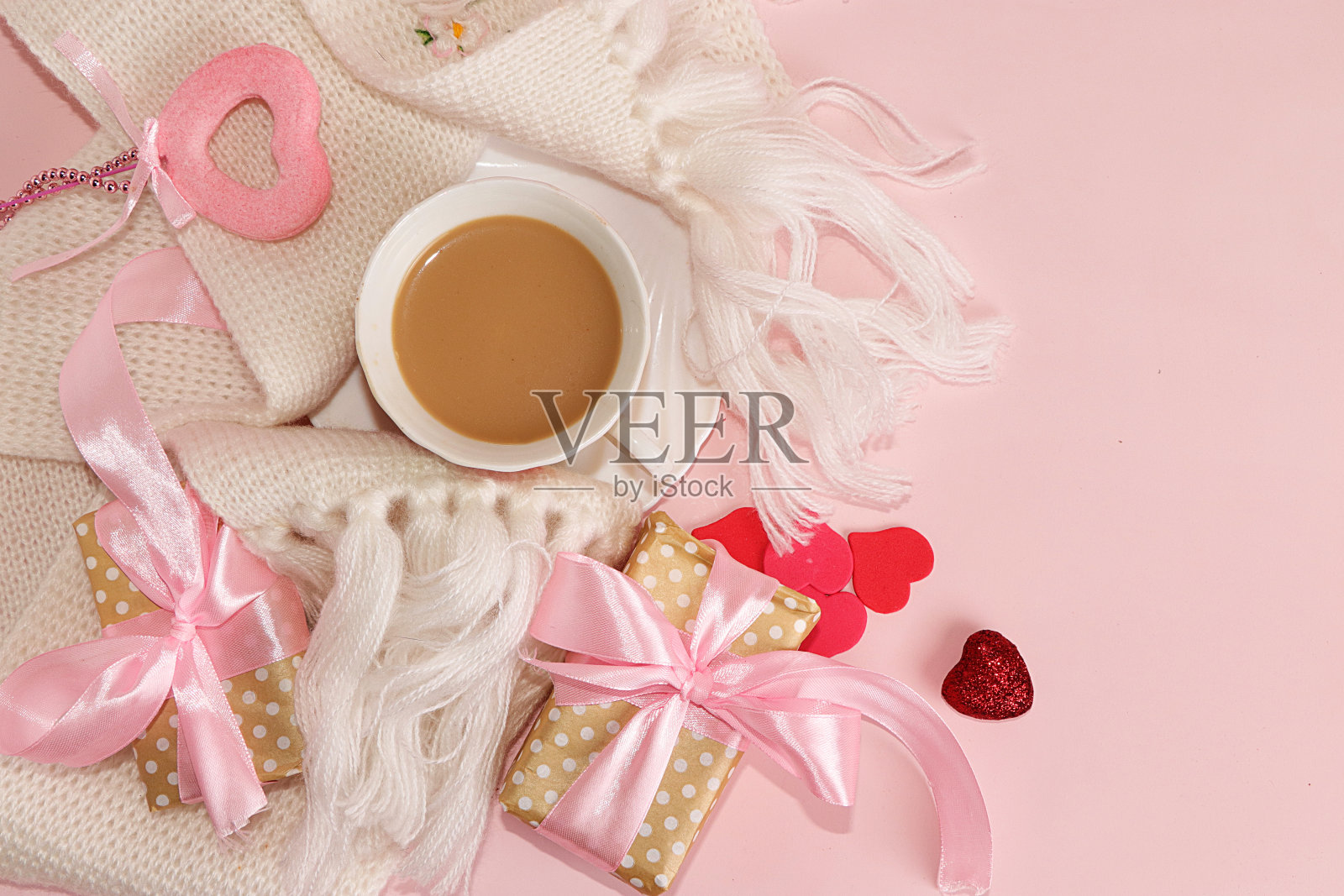 情人节或妇女节的贺卡配一杯咖啡。粉色背景上的红心和礼盒，俯视图。祝贺你的节日，Hygge风格。照片摄影图片