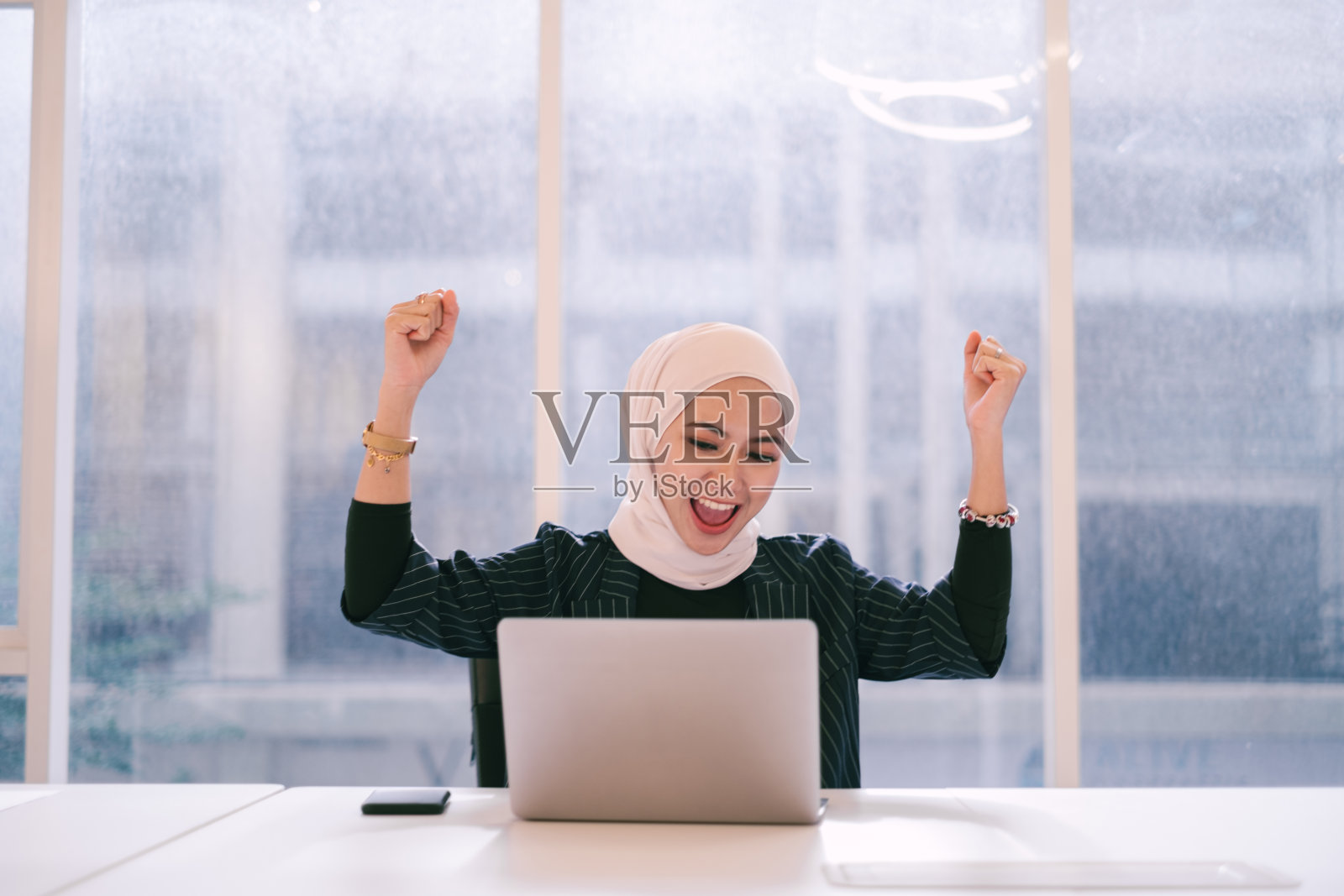 年轻的穆斯林女商人使用笔记本电脑的肖像照片摄影图片