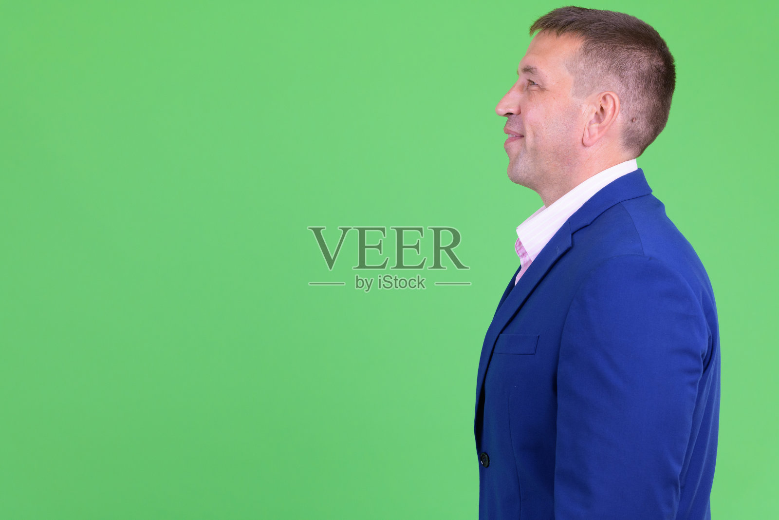 侧面视图的快乐成熟男子气概的商人在西装微笑照片摄影图片