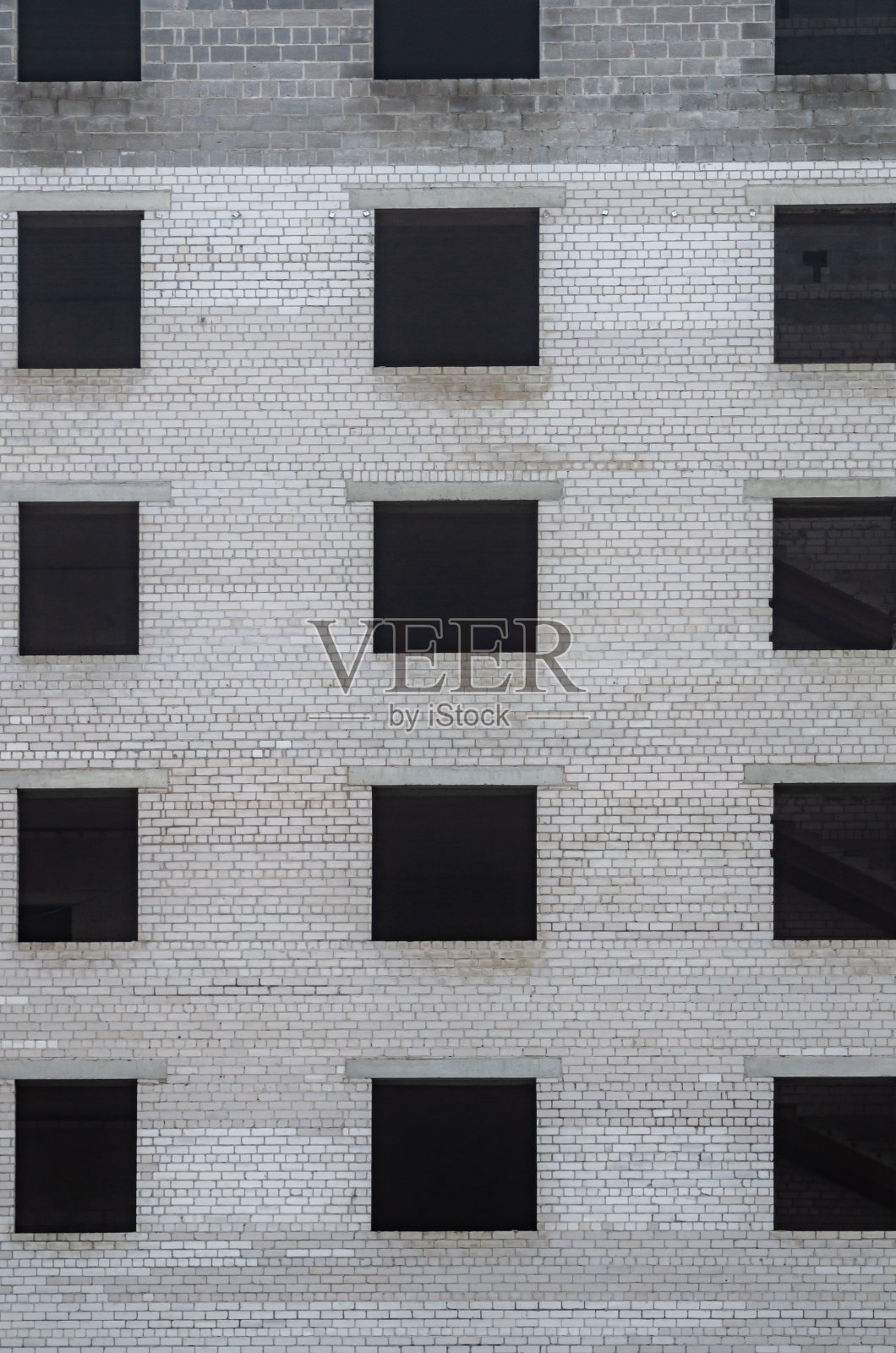 背景来自一个未完工的建筑，窗户开口，从煤渣砖和楼板。照片摄影图片