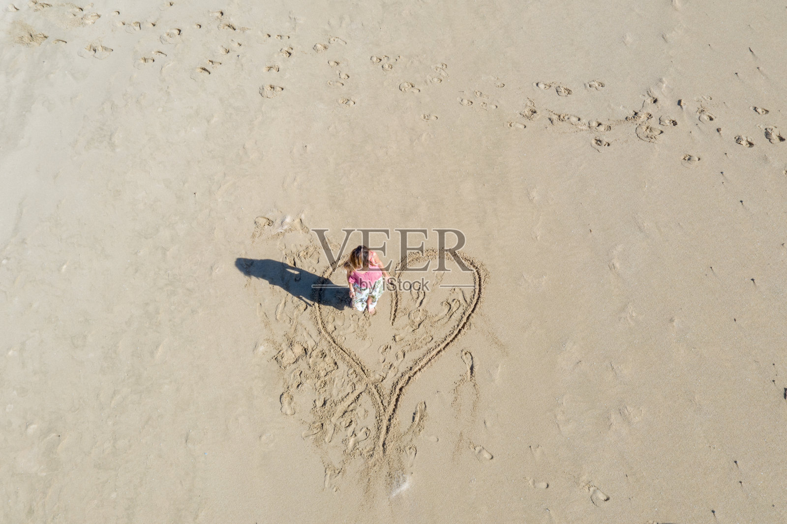 年轻女子在海滩上画心照片摄影图片