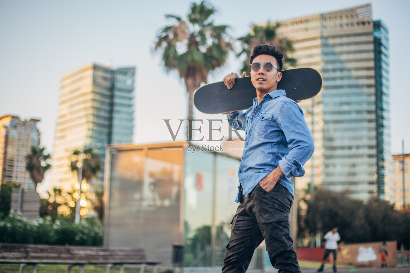 城里玩滑板的年轻潮男照片摄影图片