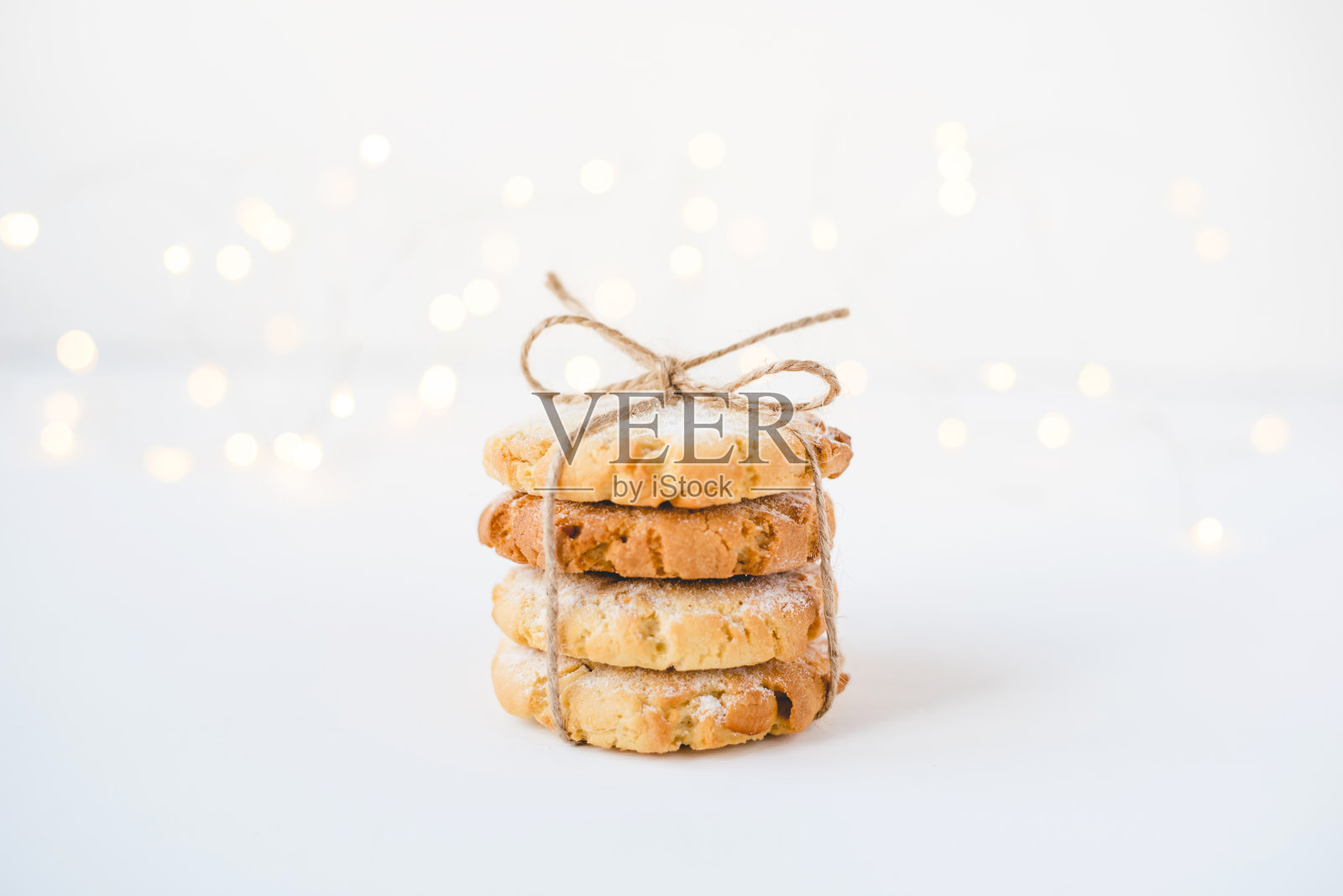 白色的木桌上放着一堆新鲜的饼干。照片摄影图片