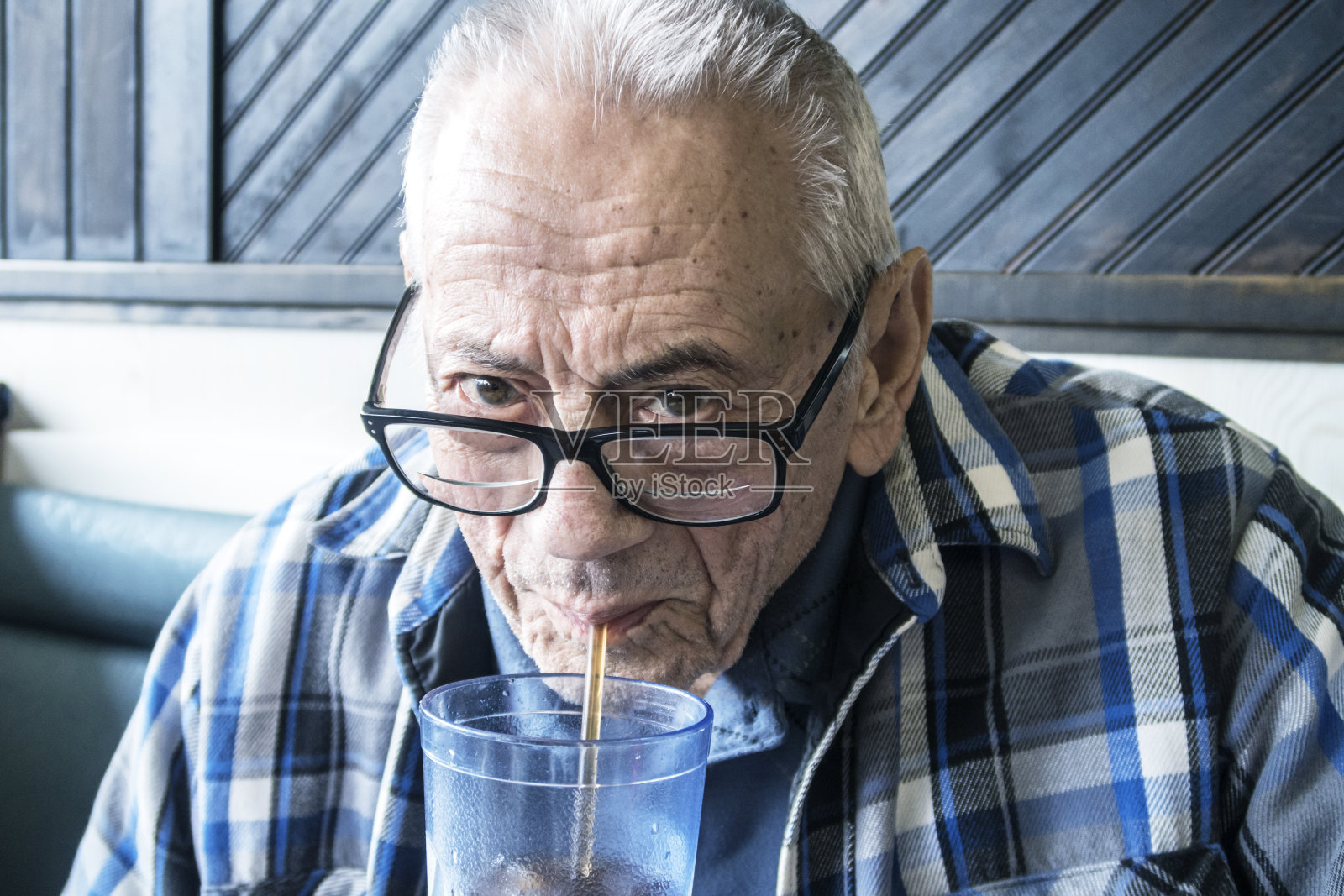 在餐厅喝苏打水的微笑老年男人照片摄影图片