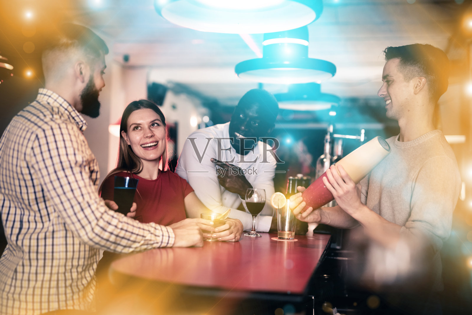 快乐的人们和调制鸡尾酒的调酒师照片摄影图片