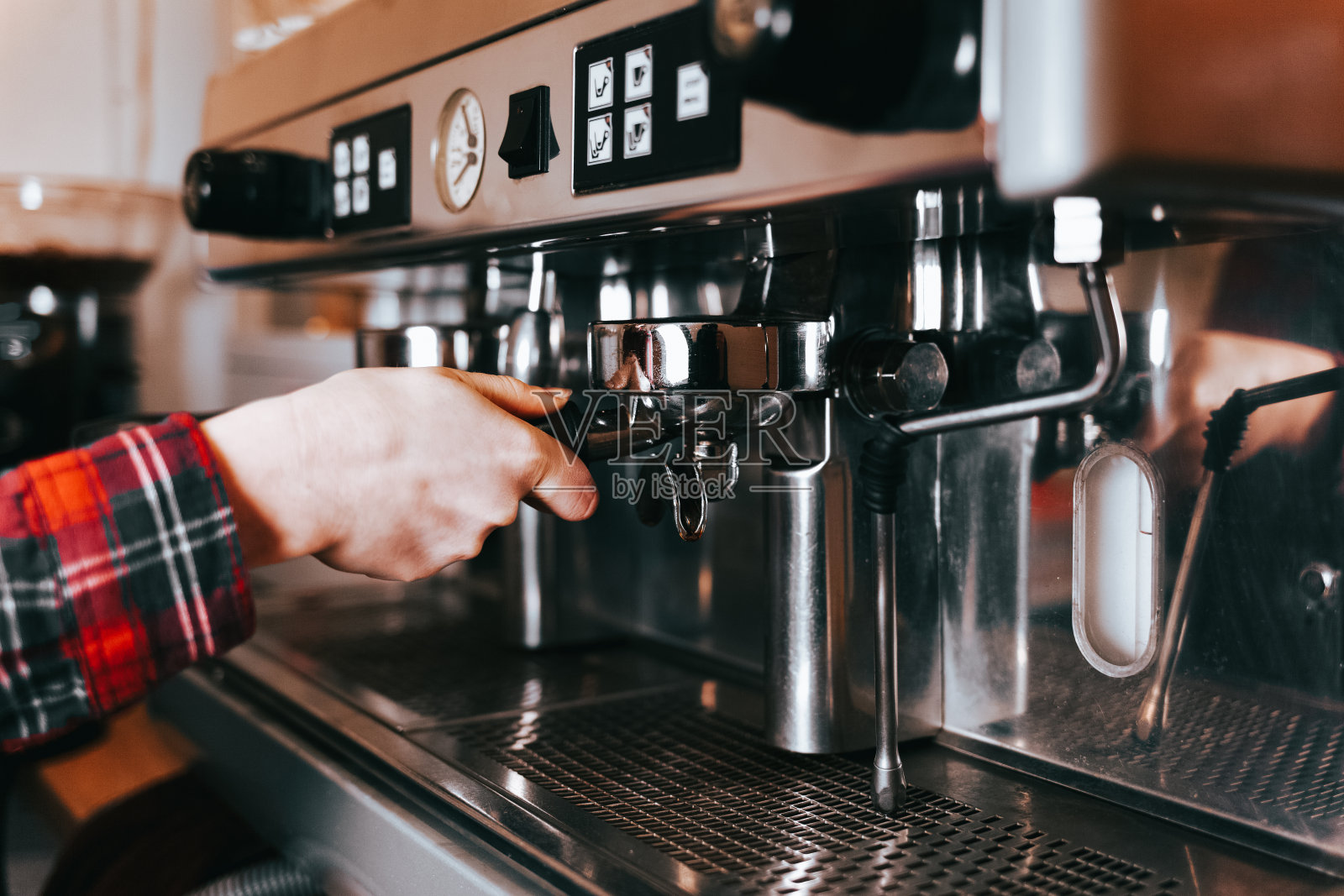 咖啡师煮芳香的咖啡。在咖啡机上煮拿铁咖啡的过程照片摄影图片