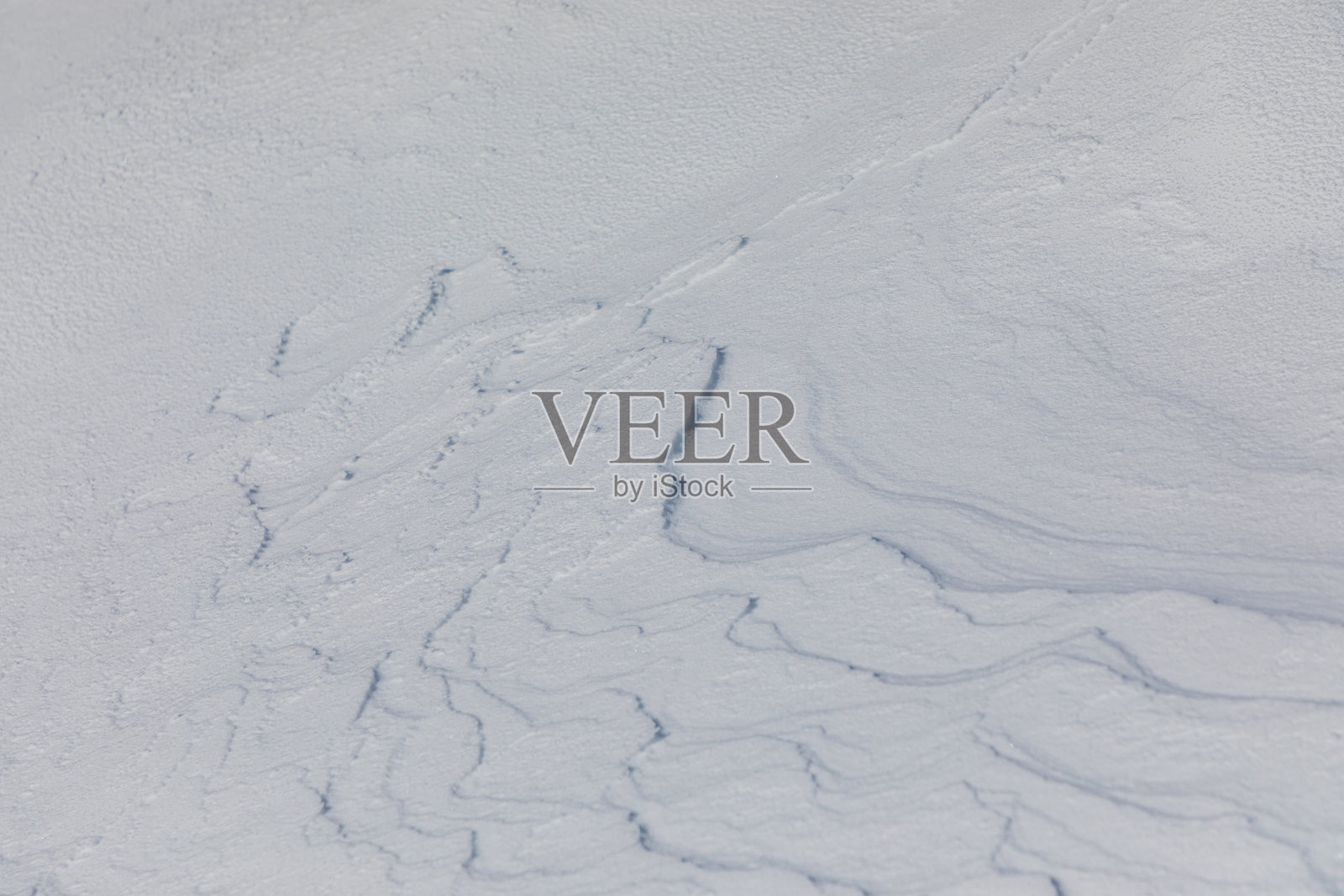 风在雪中形成波浪状的形状照片摄影图片