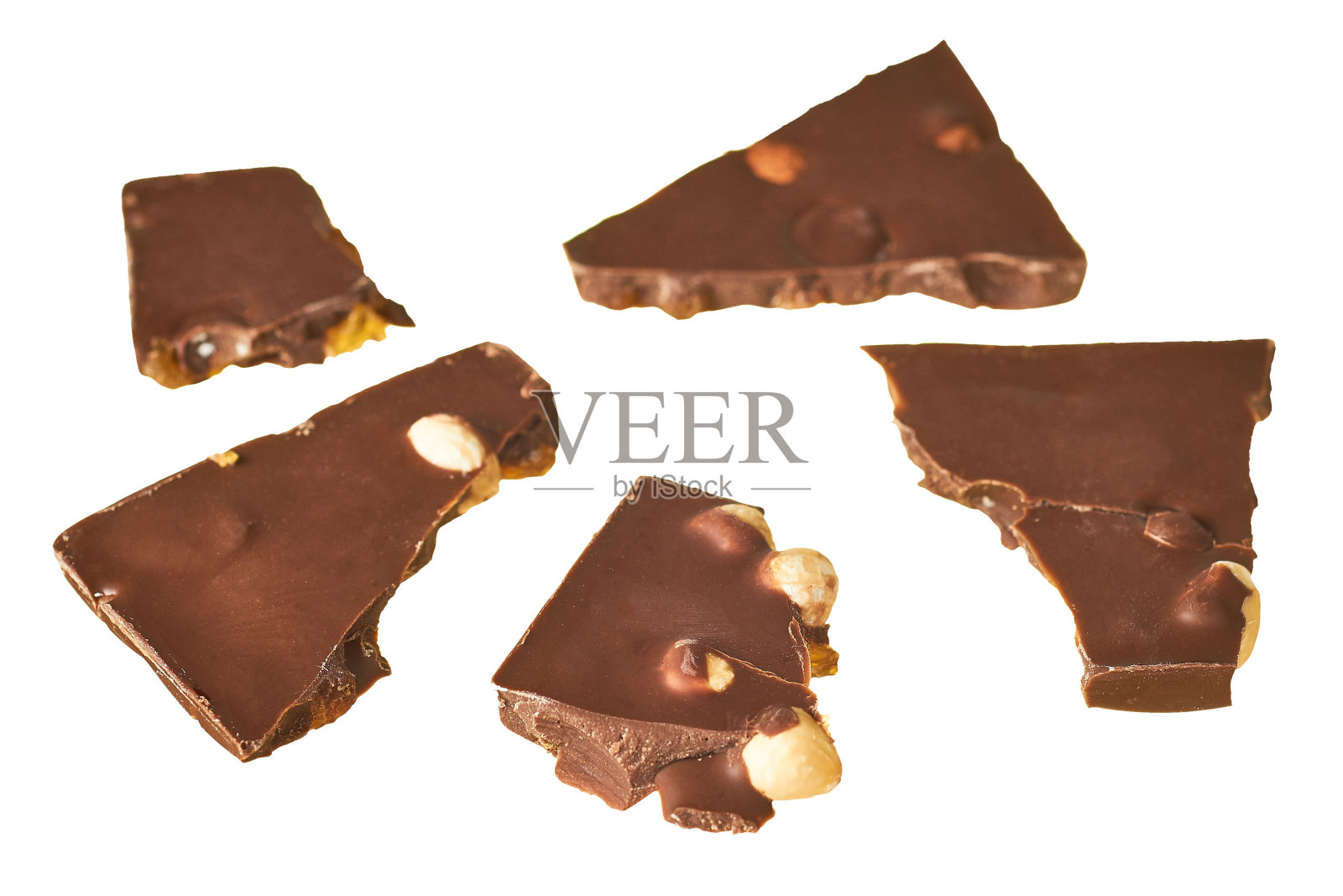 在白色的背景上，散落着带花生和葡萄干的长方形巧克力棒照片摄影图片