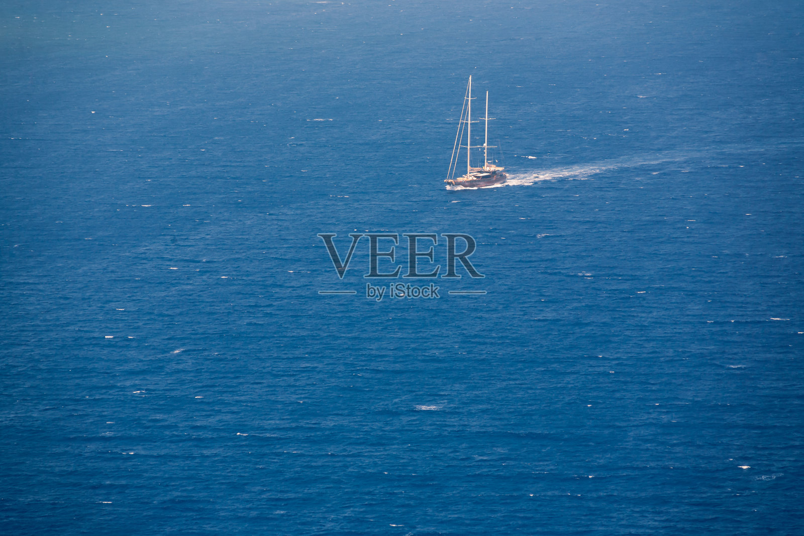 在阳光明媚的天气，从圣托里尼的伊亚村和船上的海景照片摄影图片