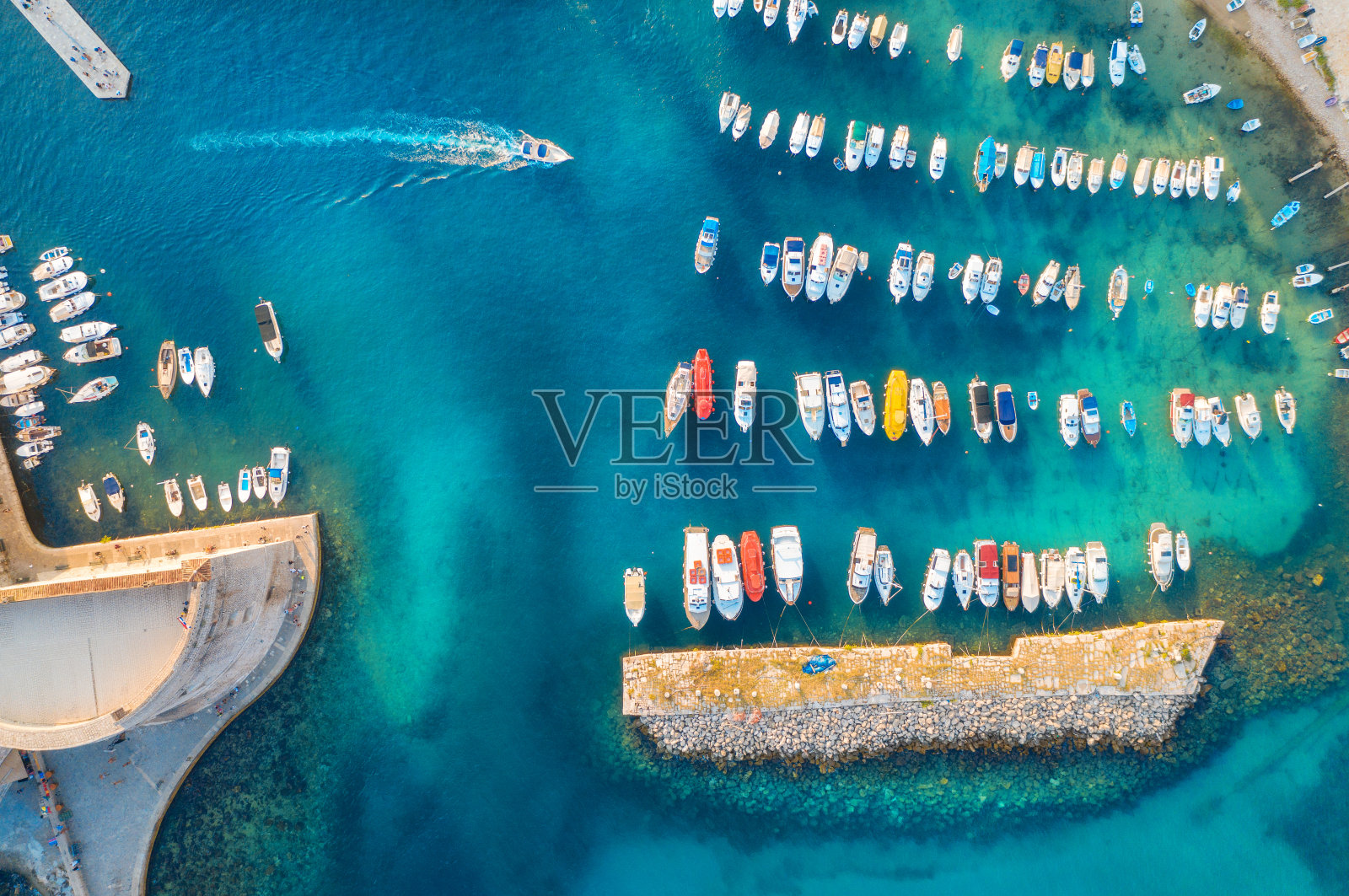 鸟瞰图的五颜六色的船和游艇在港口在蓝色的海洋日落。杜布罗夫尼克的夏日风景，美丽的摩托艇，码头，清澈的海水。从港口上方俯瞰。旅行照片摄影图片