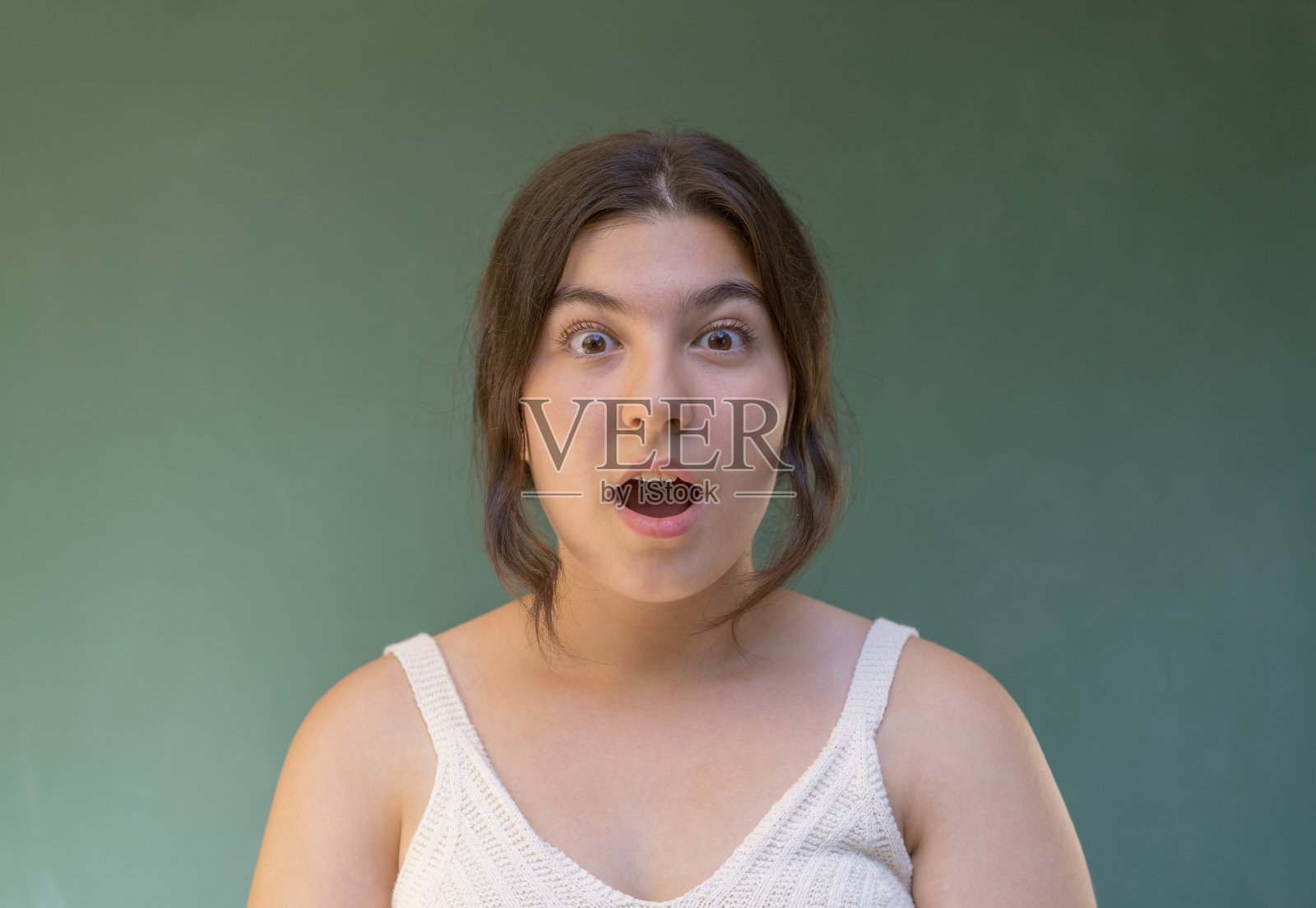 惊讶的少女在绿色的背景照片摄影图片