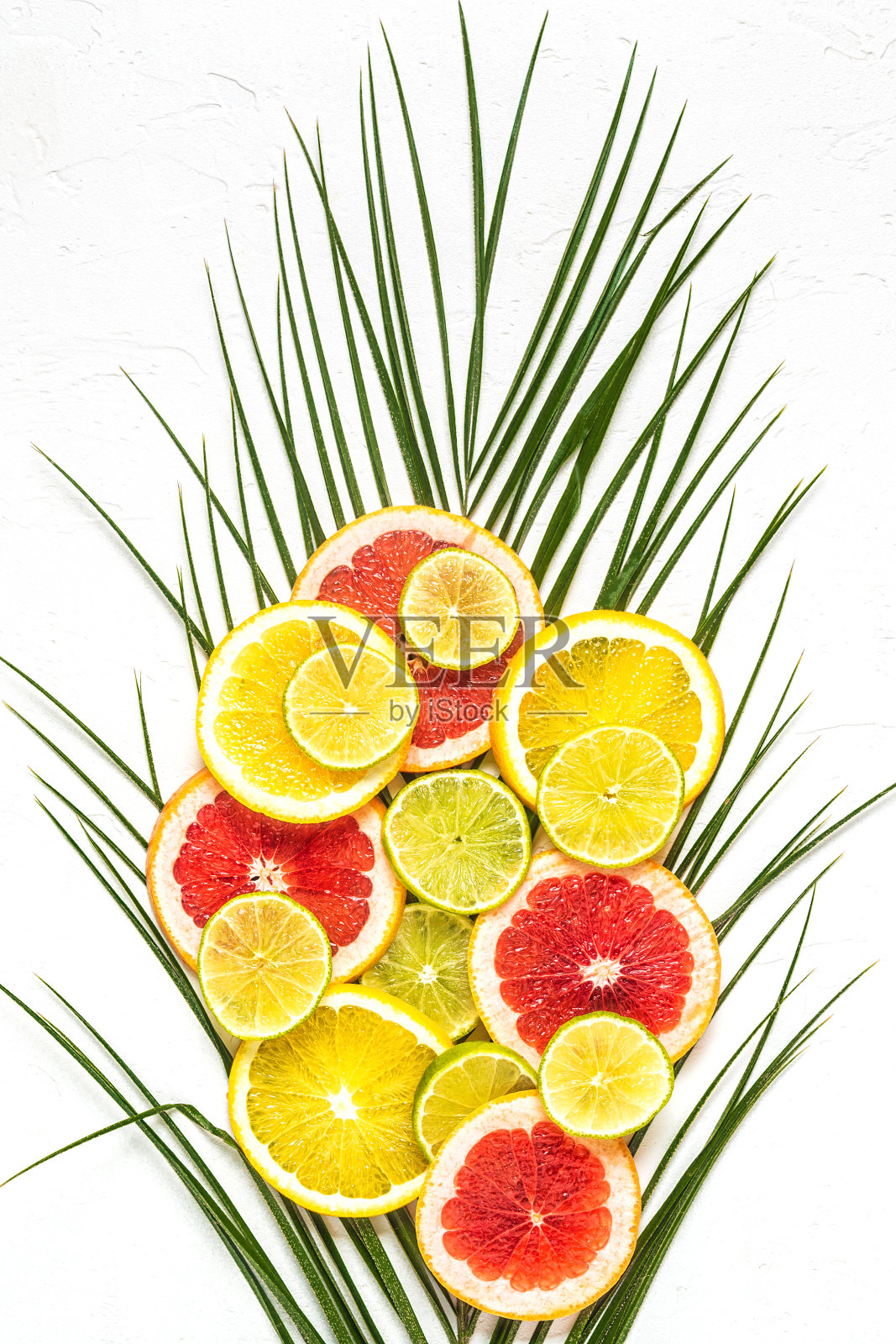 白色背景上的热带水果和棕榈叶照片摄影图片