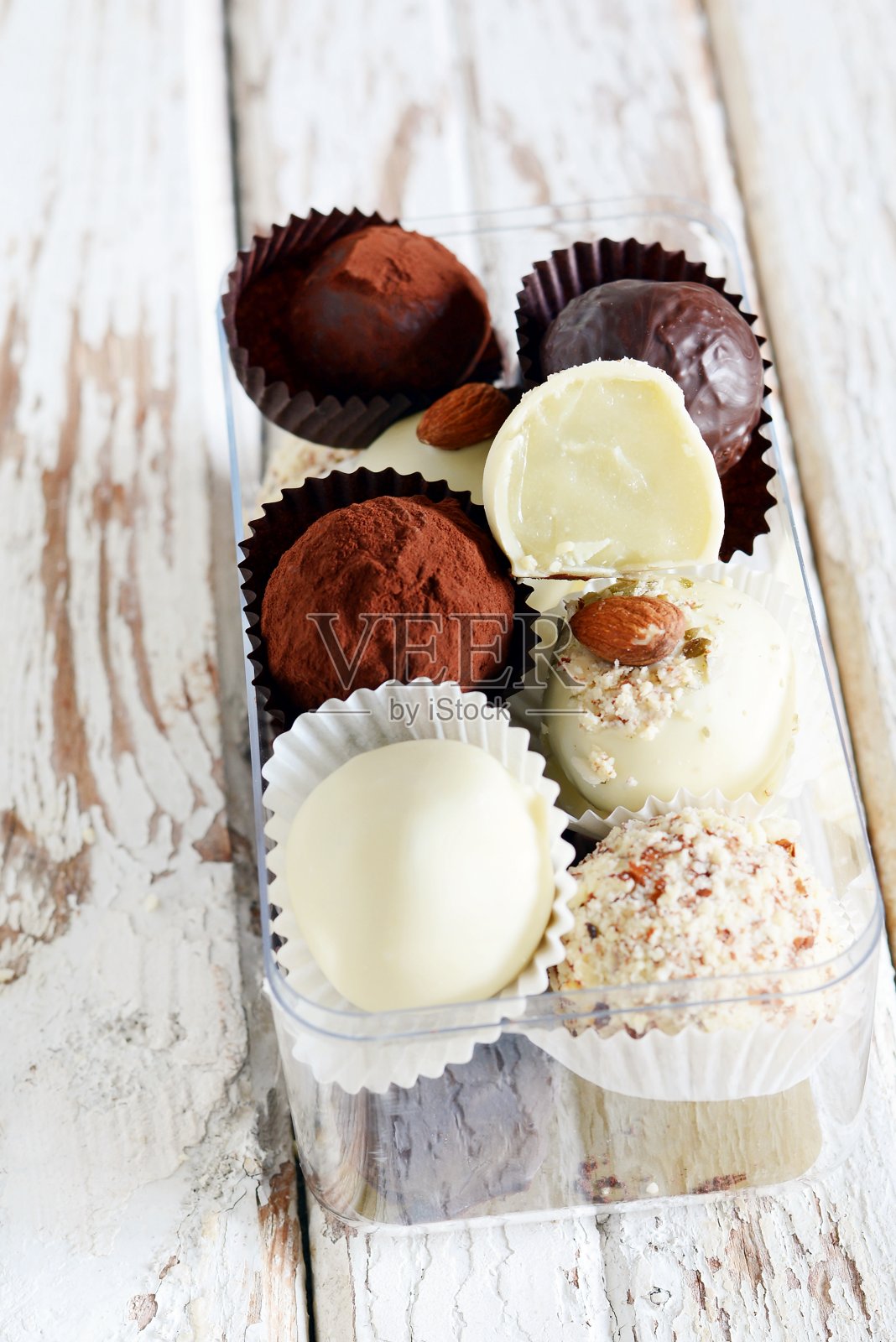 巧克力松露在一个玻璃盒子，在一个白色的复古背景。自制的新鲜能量球。情人节礼物，生日照片摄影图片