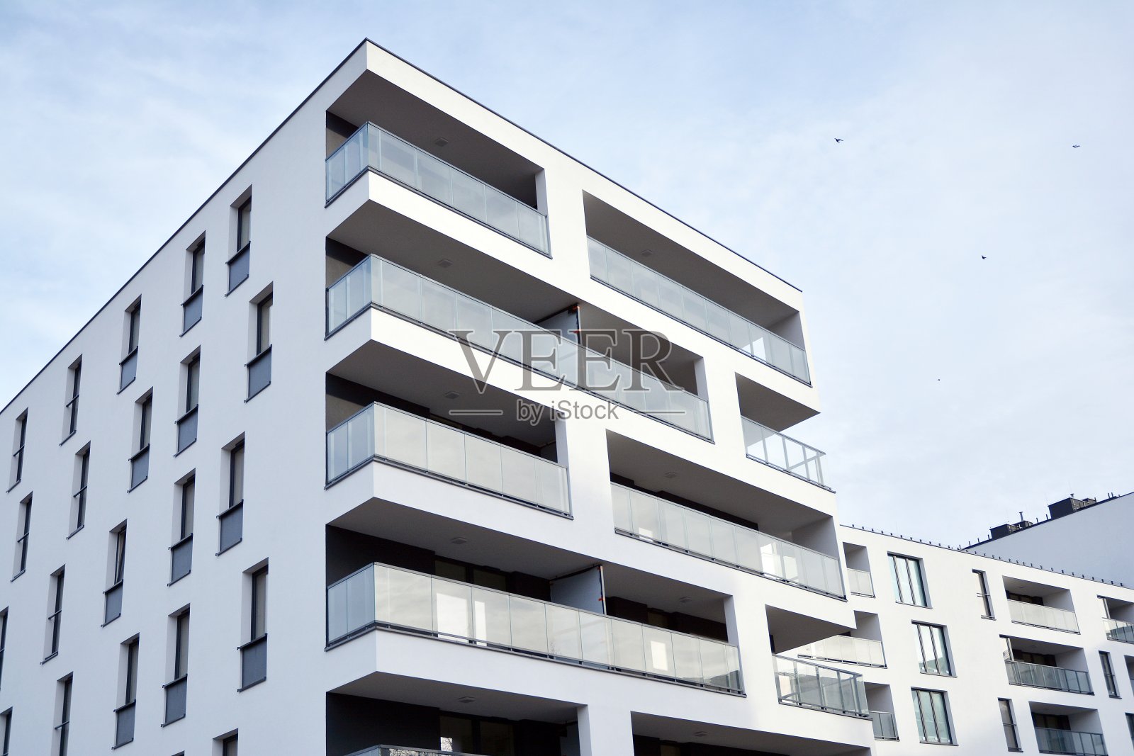 阳光照射在城市建筑上的光效应。现代住宅公寓的片段，外部是扁平的建筑。新豪宅及住宅综合体的细节。照片摄影图片