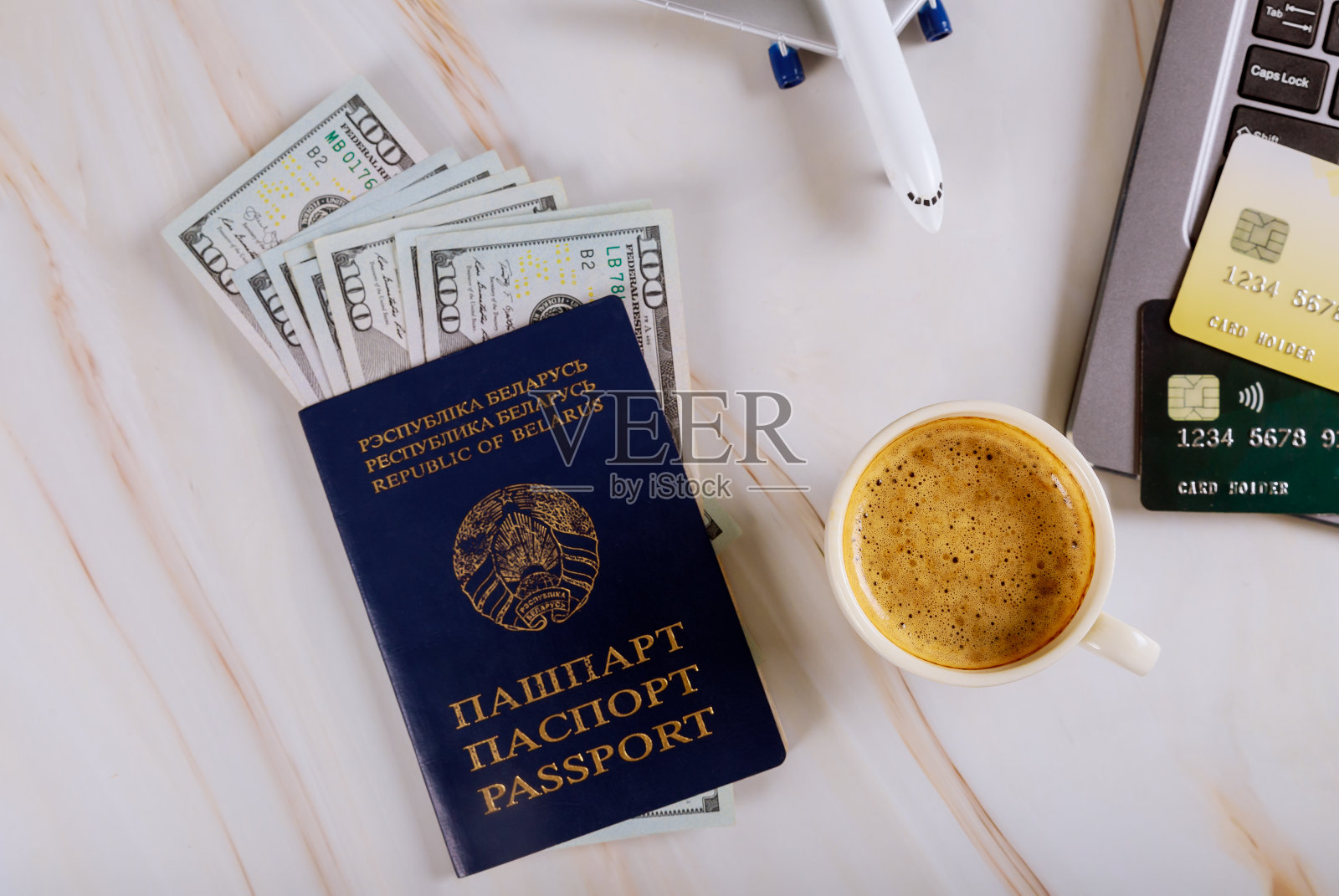 在线购买机票，使用笔记本电脑购买机票，配有白俄罗斯护照和美元纸币照片摄影图片