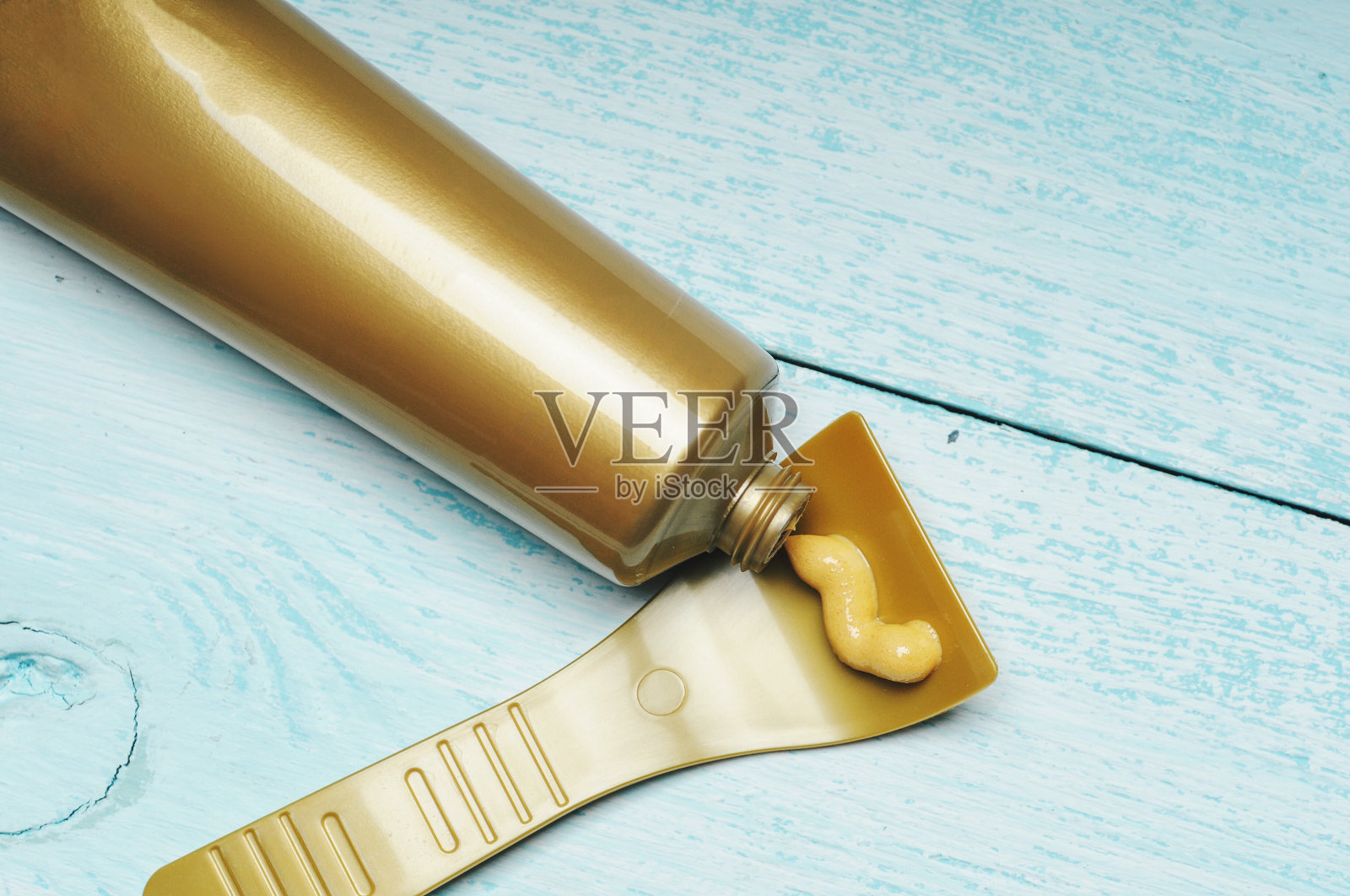 金色脱毛膏近距离挤压出管上抹刀照片摄影图片