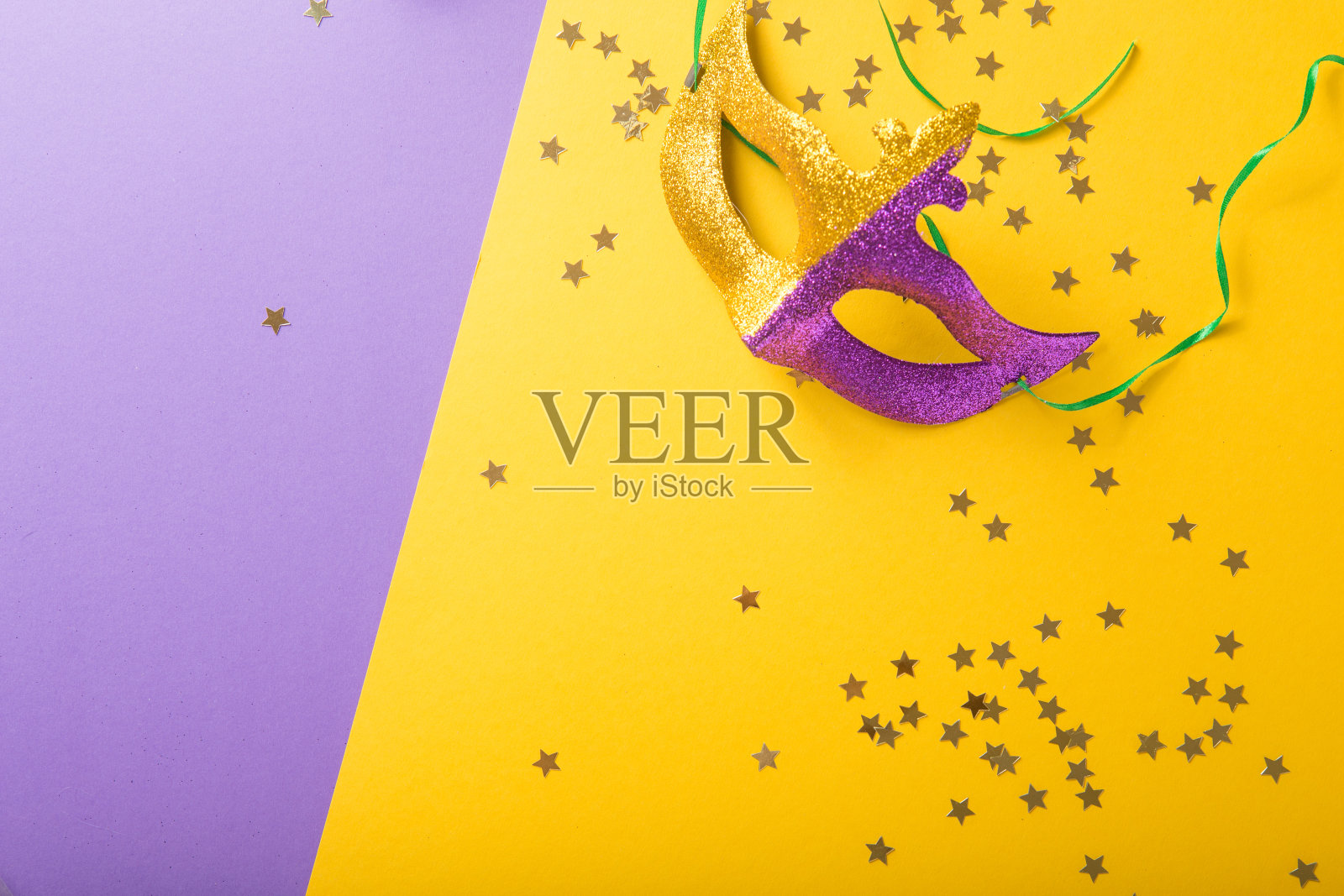 狂欢节以黄紫色为背景的一组节日的、色彩丰富的狂欢节或狂欢节面具威尼斯的面具。照片摄影图片