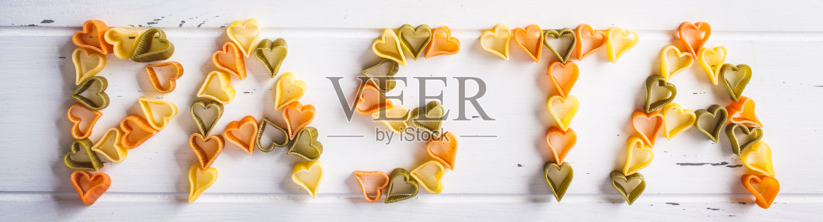 字意面由心意面在白色木制背景，俯视图。照片摄影图片