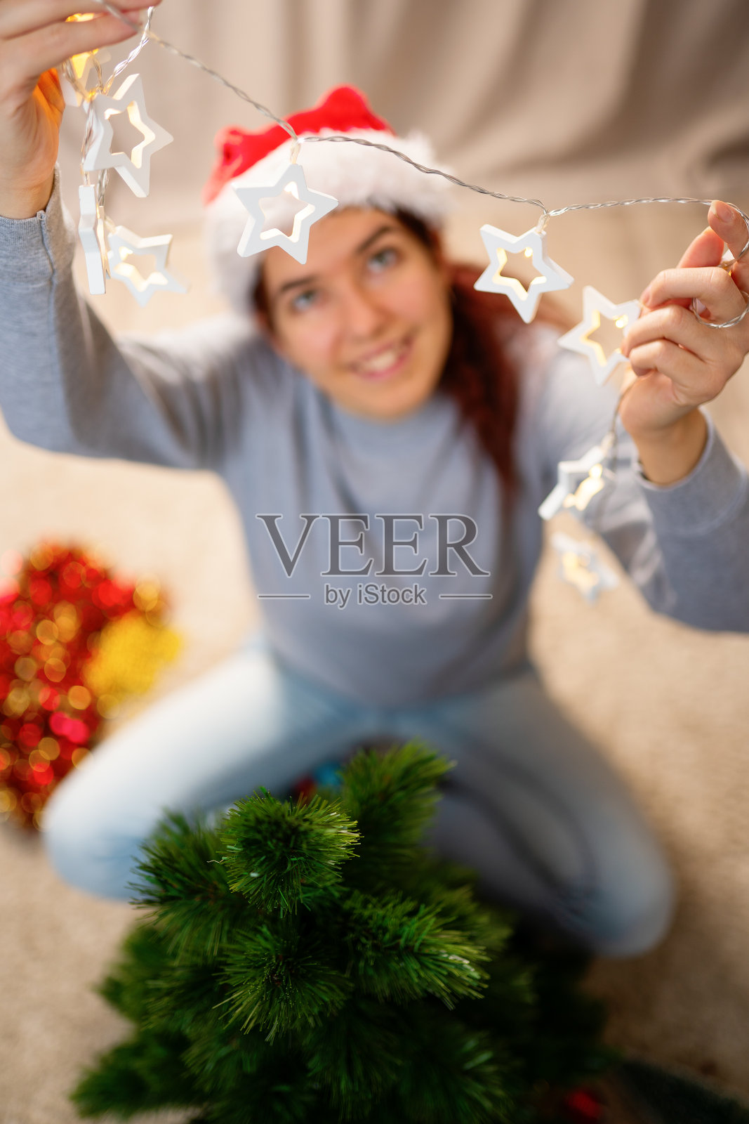 微笑的女人用花环装饰新年树照片摄影图片
