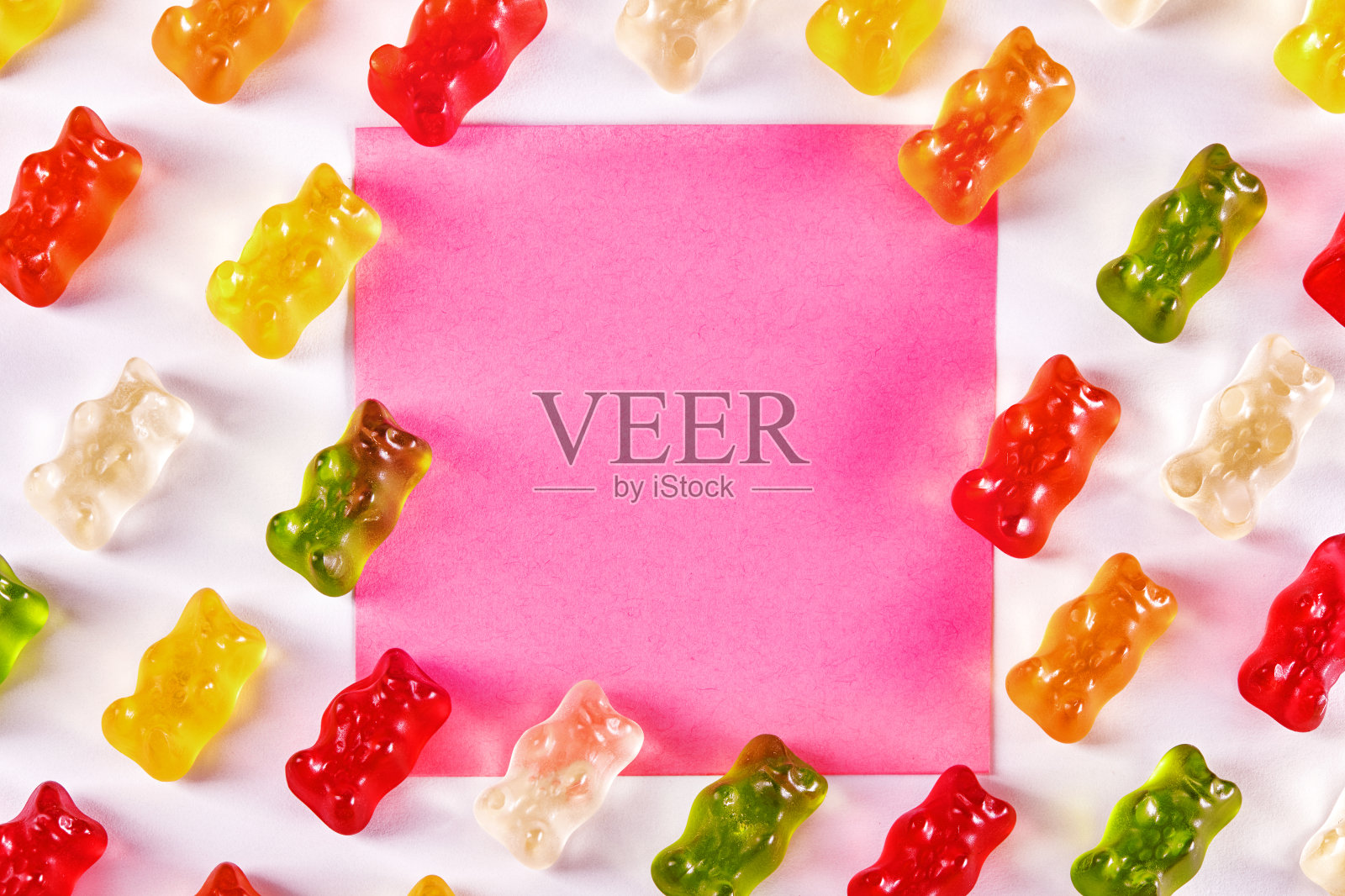 平铺设计的小熊软糖与粉红色空白便条纸照片摄影图片