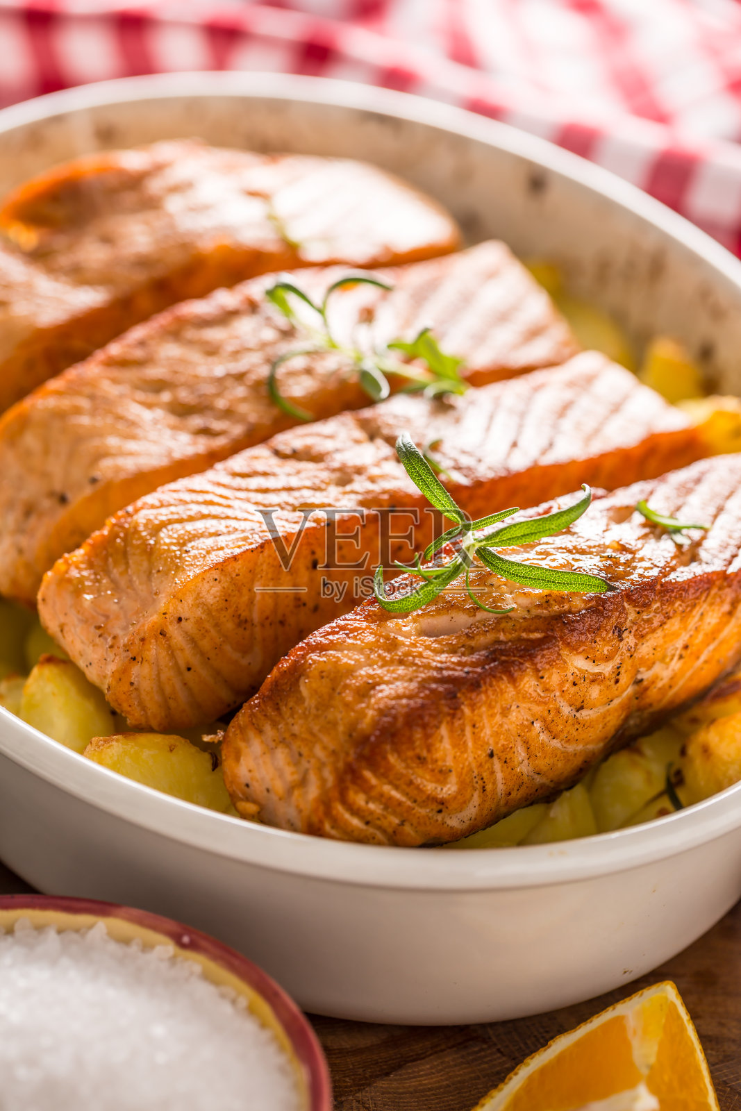 烤三文鱼片配土豆和香草放在烤盘里照片摄影图片